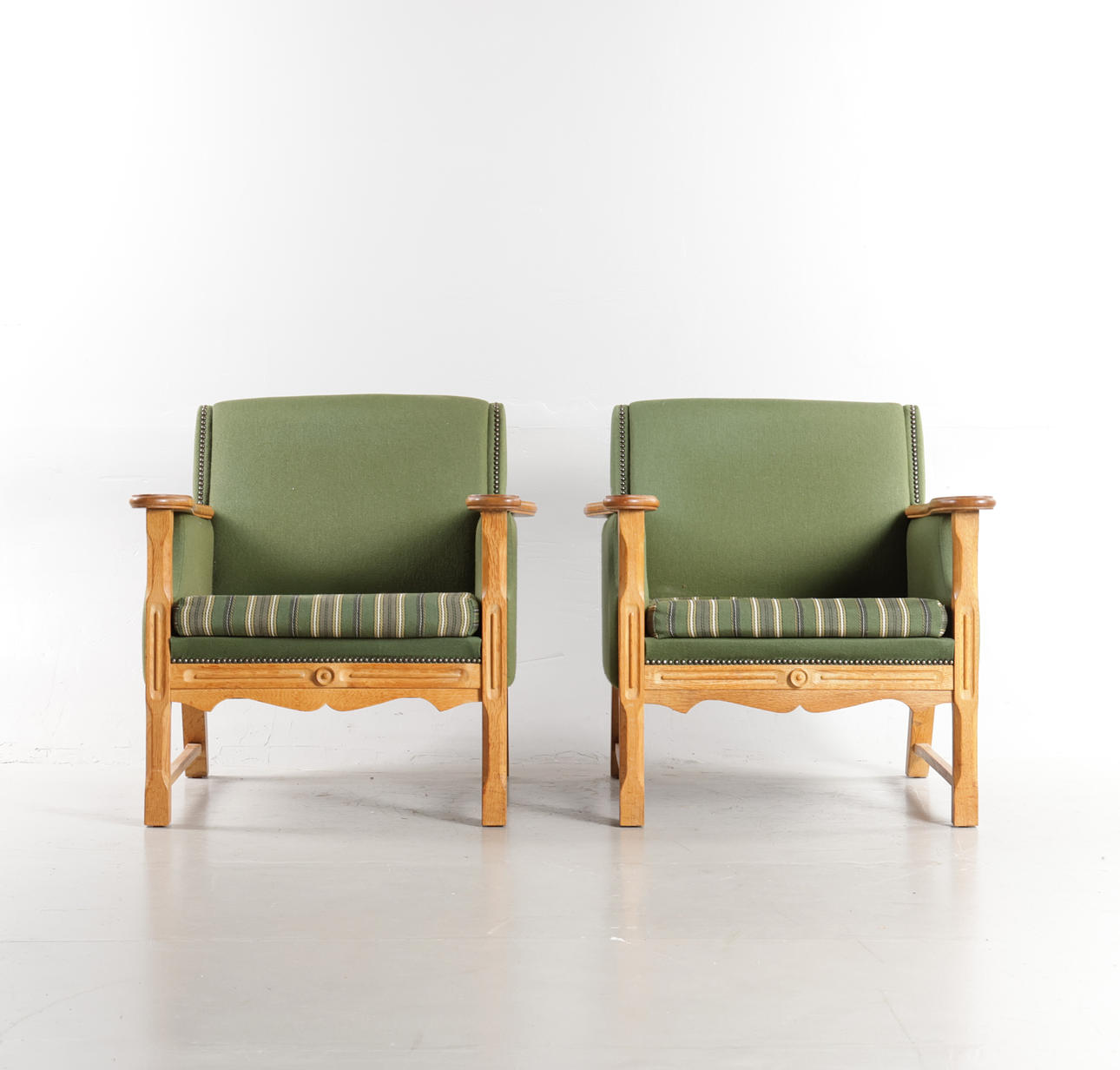 DANSK MØBELDESIGN. A pair of armchairs upholstered in wool, oak frame with carvings, 1970s - Henry Kjærnulf-style (2).