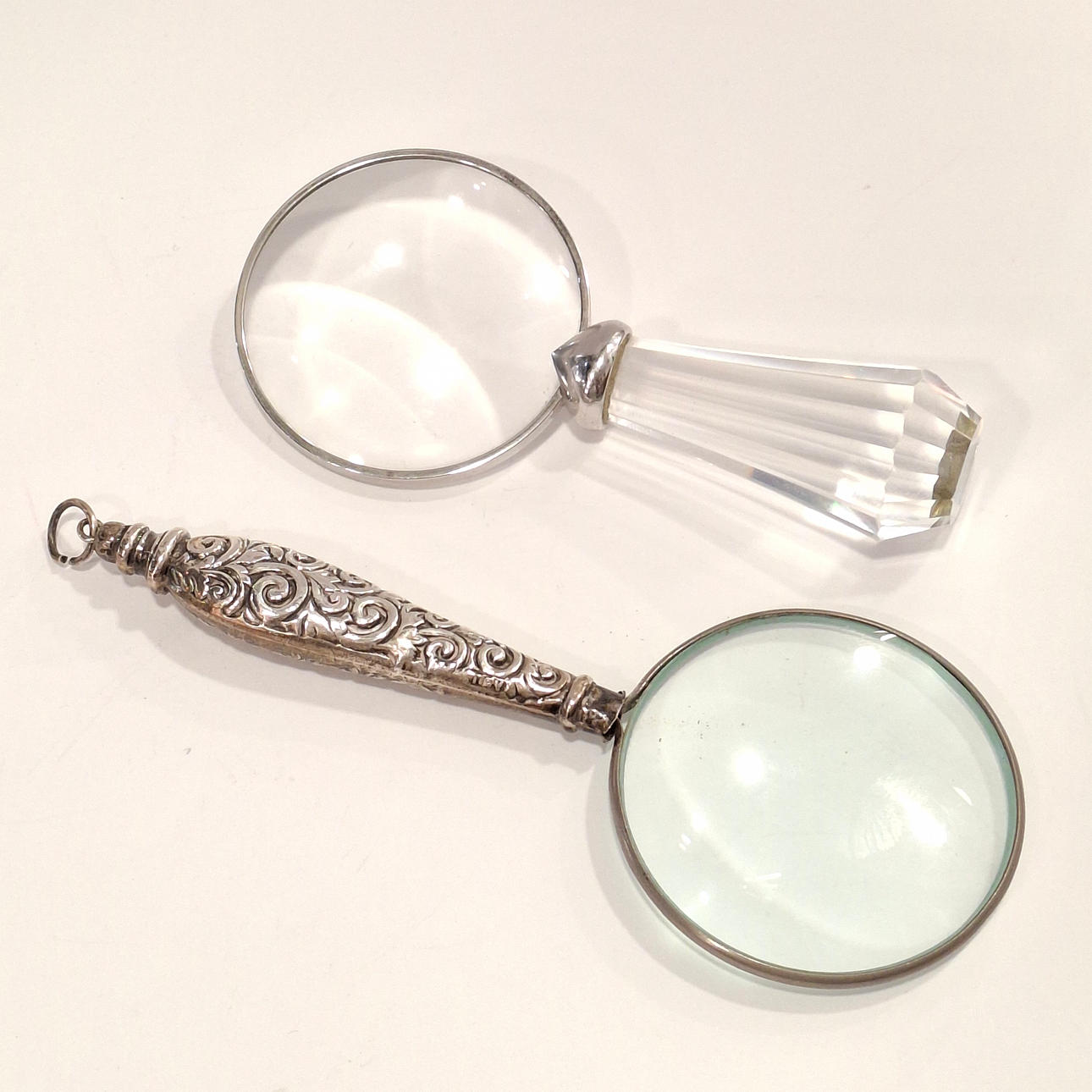 2 Lupen mit silbernen Griffen und facettiertem Glas.