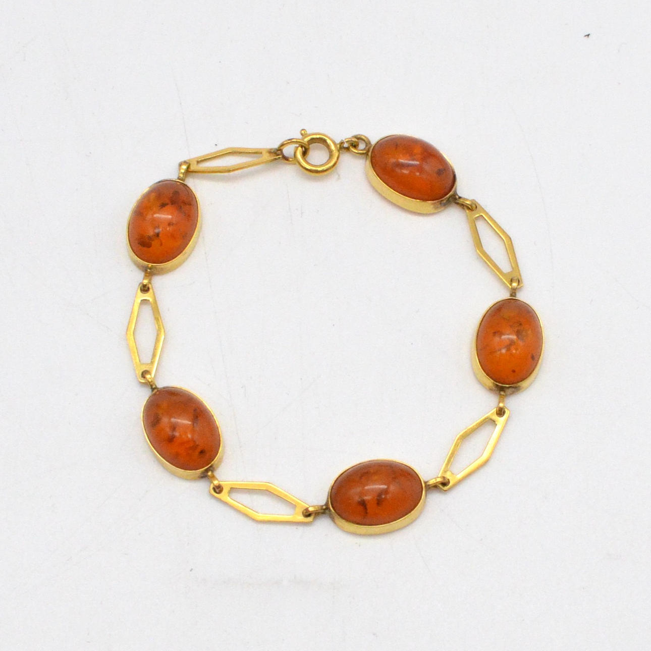 LINK BRACELET WITH AMBER CABOCHON, GOLD-PLATED AND OPENWORK SETTING, AROUND 1950.