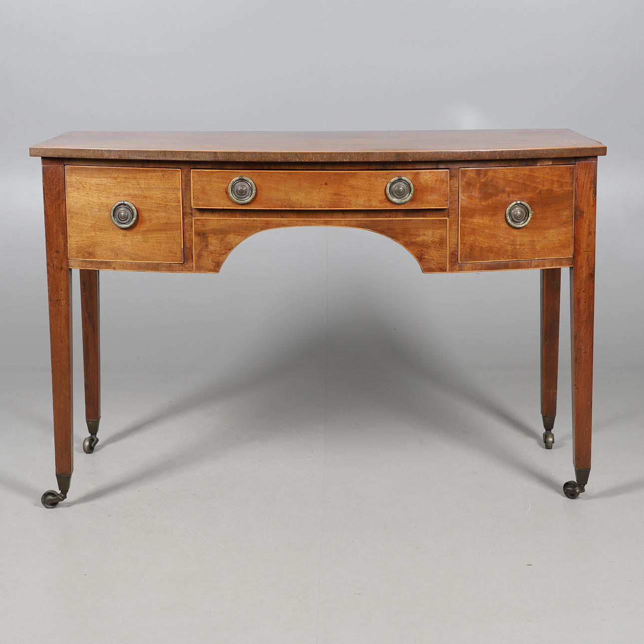 A MAHOGANY BOW FRONTED KNEEHOLE DESK.