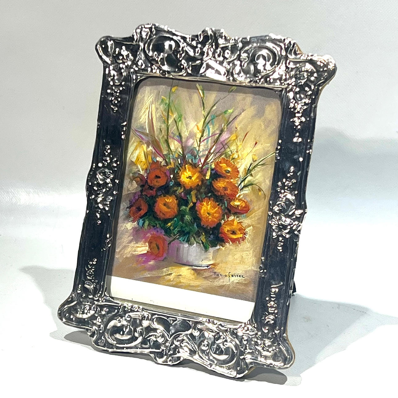 1940s English frame in punched and embossed silver forming scrolls.