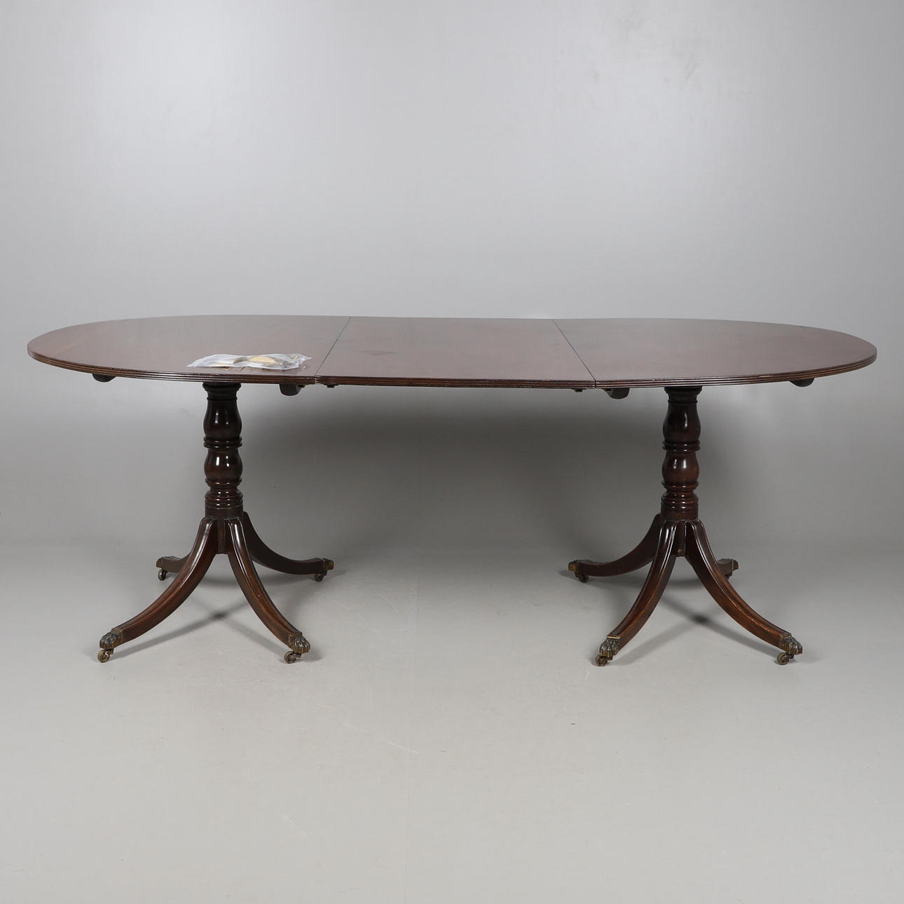 A MAHOGANY EXTENDING D END DINING TABLE.