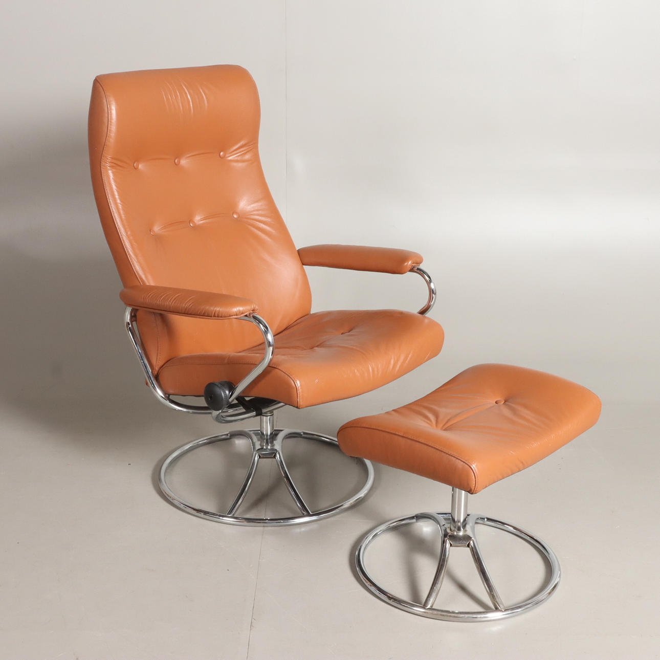 SPINNING ARMCHAIR WITH FOOTSTOOL.