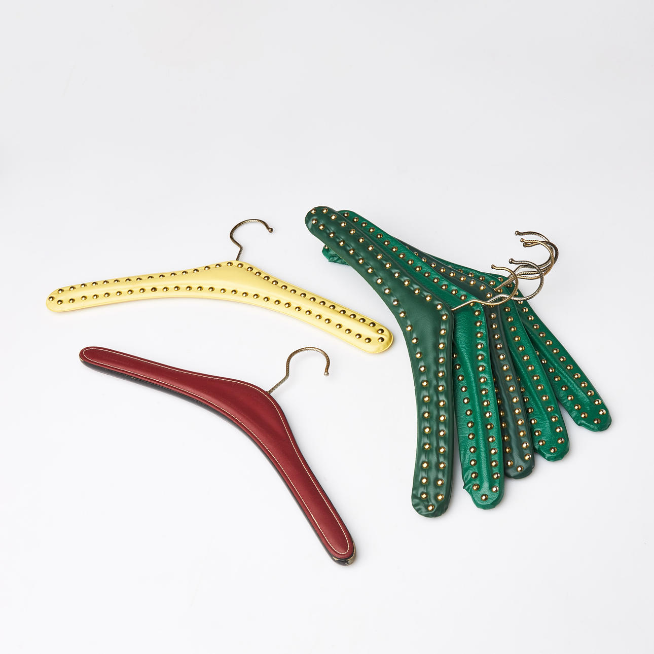A set of 7 hangers, 1950s/60s, similar. Clad in gallons with brass buttons.