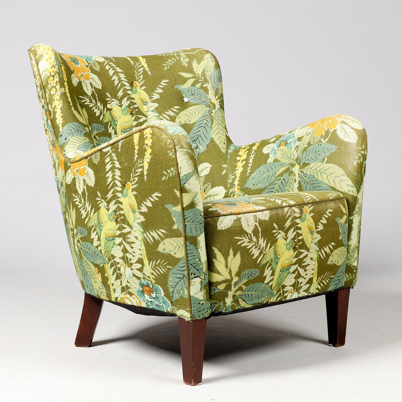 Upholstered armchair with buttoned back and legs of stained beech, Danish cabinetmaker, first half of the 20th century.