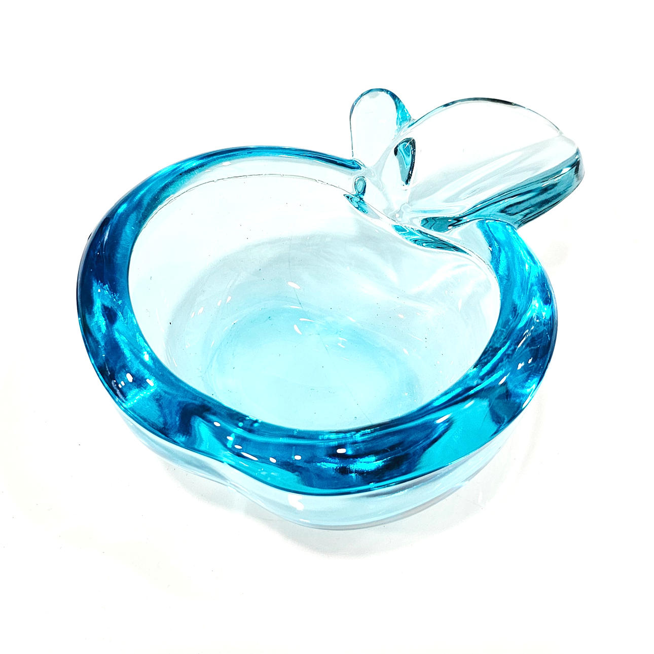 Aschenbecher aus Glas in Form eines halben Apfels.