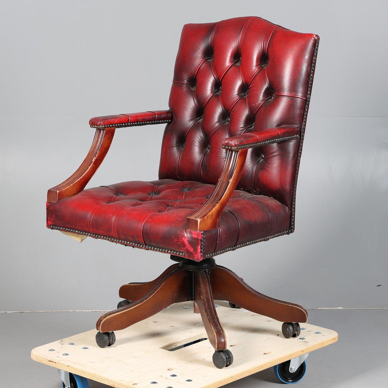 A RED LEATHER BUTTON DOWN SWIVEL DESK CHAIR.