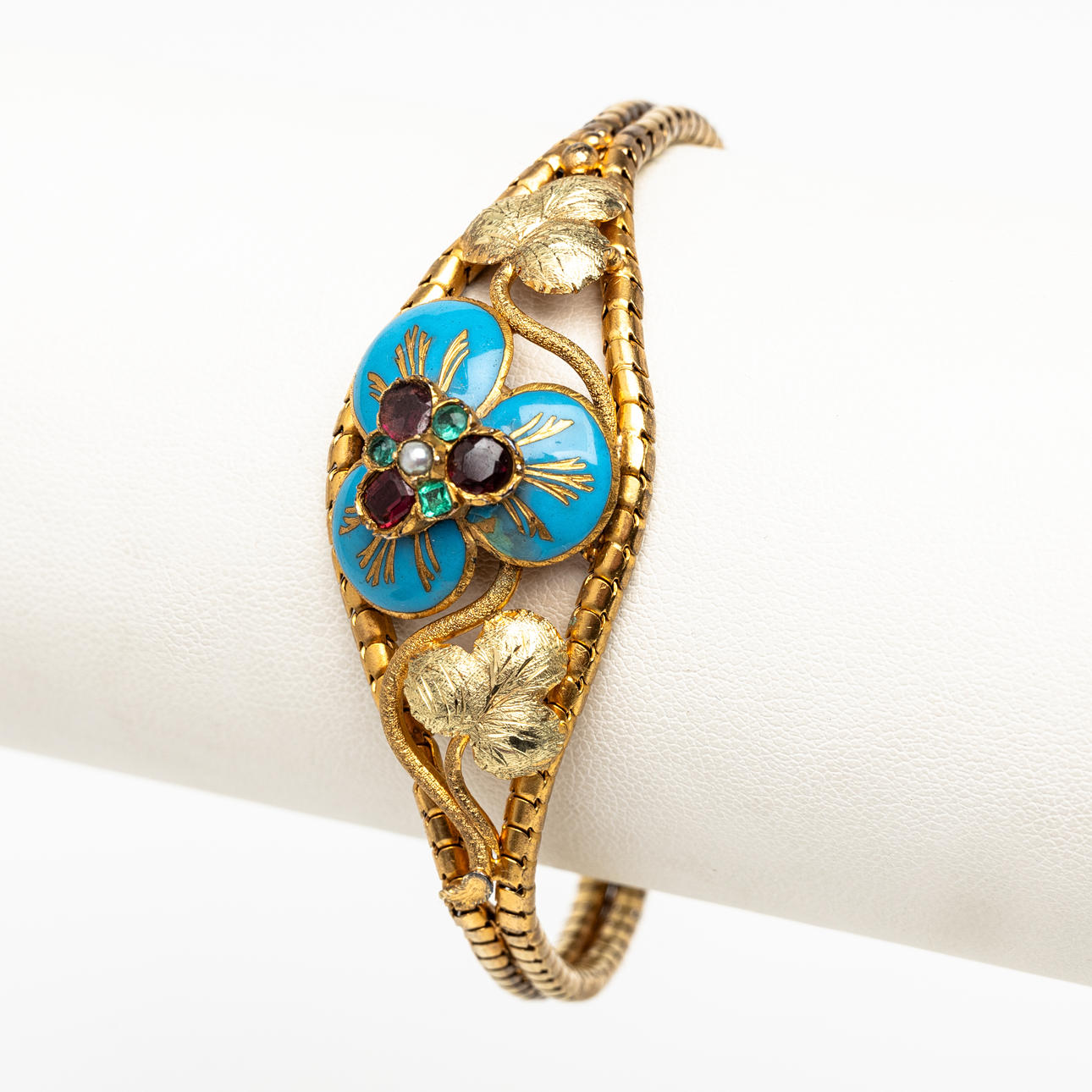 ARMBAND 15k guld med blå emalj, granater och gröna stenar, England 1850. I originaletui.
