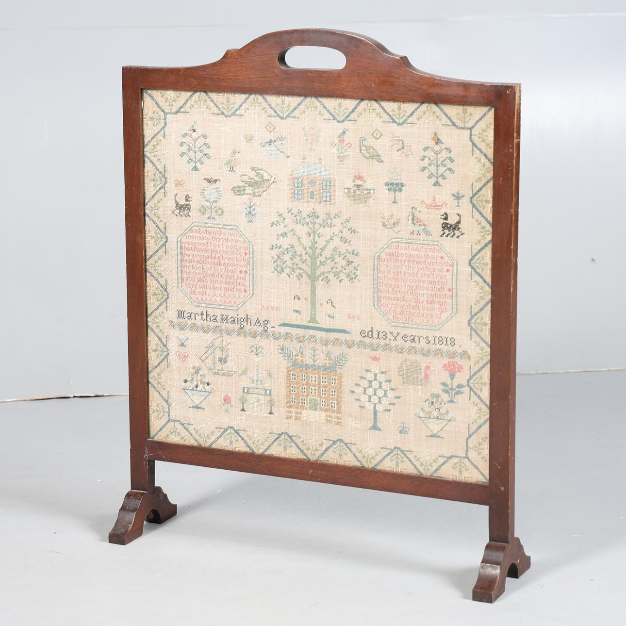 A GEORGE III NEEDLEWORK SAMPLER MOUNTED AS A FIRESCREEN.