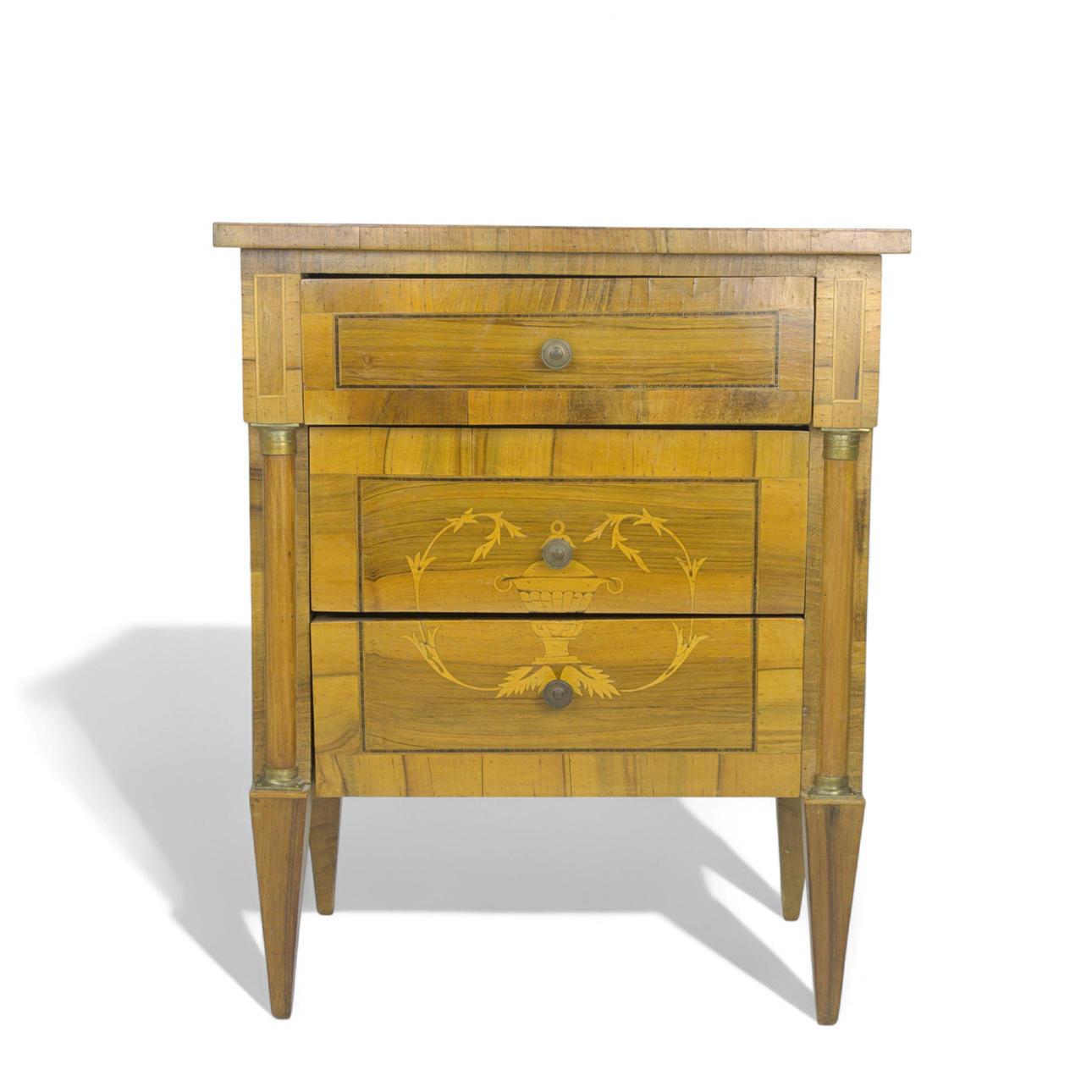 A Gustavian style chest of drawers, yew with intarsia elements, columns with brass details, 20th century.