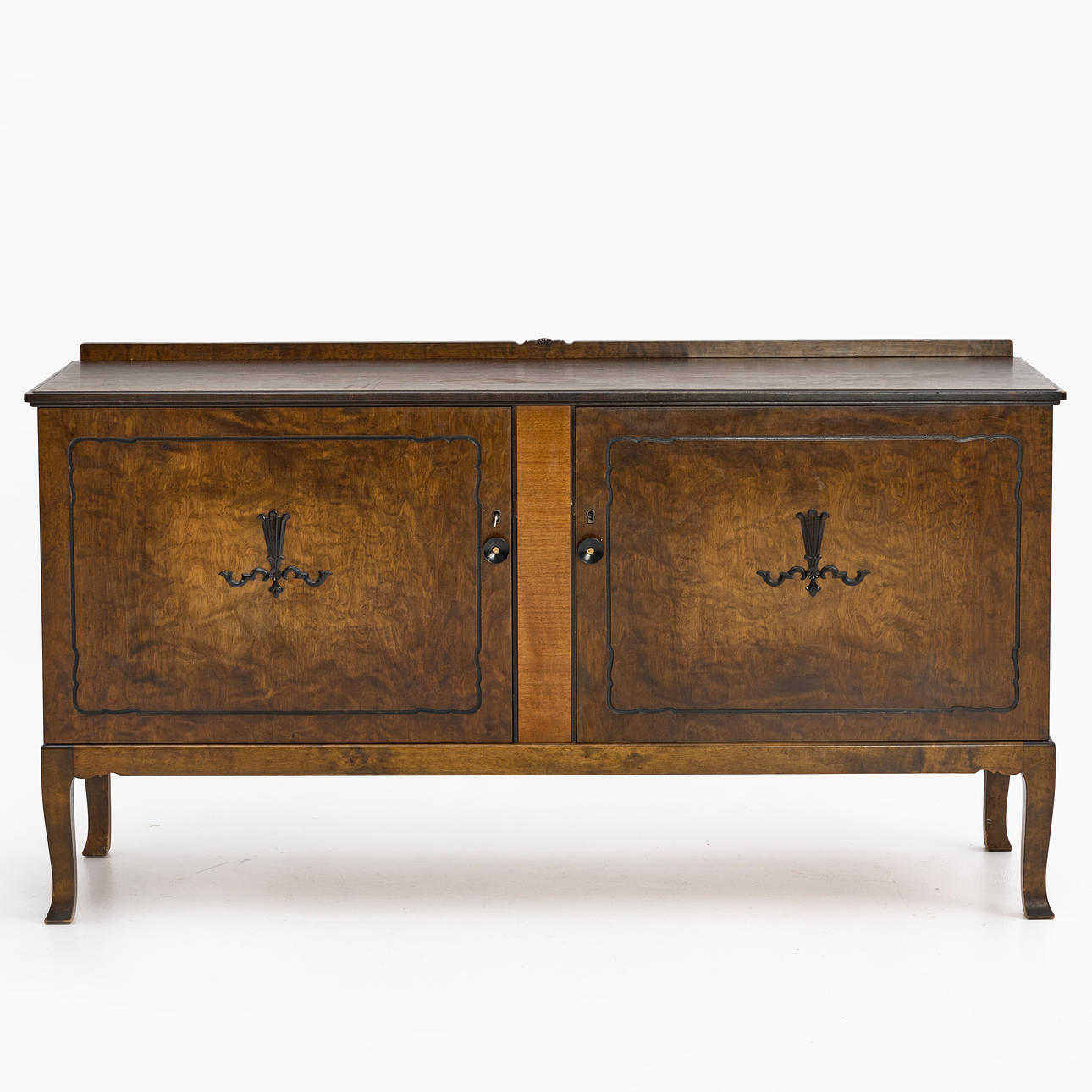 A stained birch sideboard, 1930s/40s. Drawer and shelf decor behind two doors with relief decor.