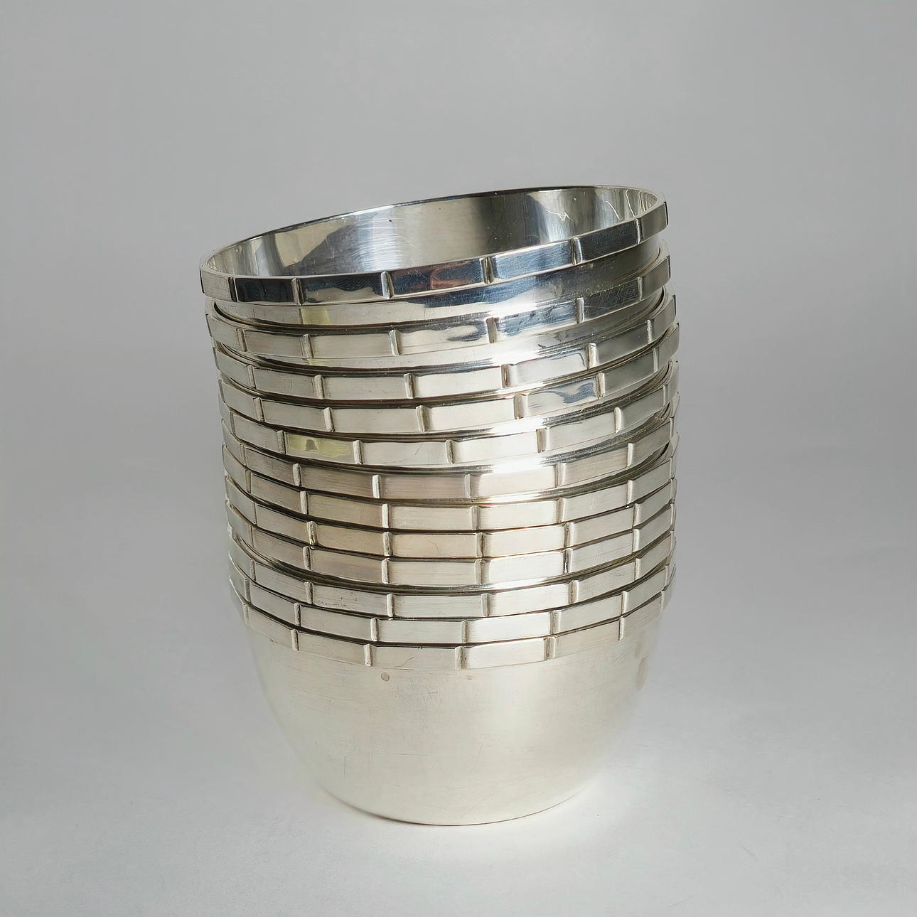 TWELVE STACKABLE BOWLS IN PUNCHED SILVER.
