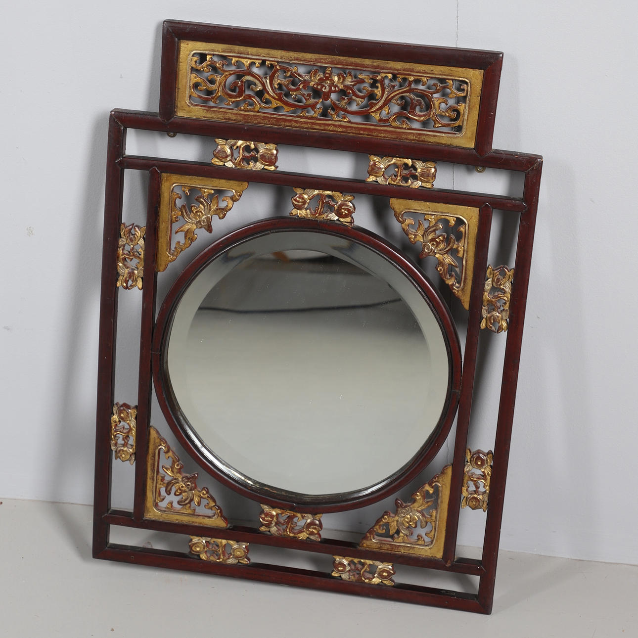 UN ESPEJO DE PARED ORIENTAL CON MARCO RECTANGULAR.