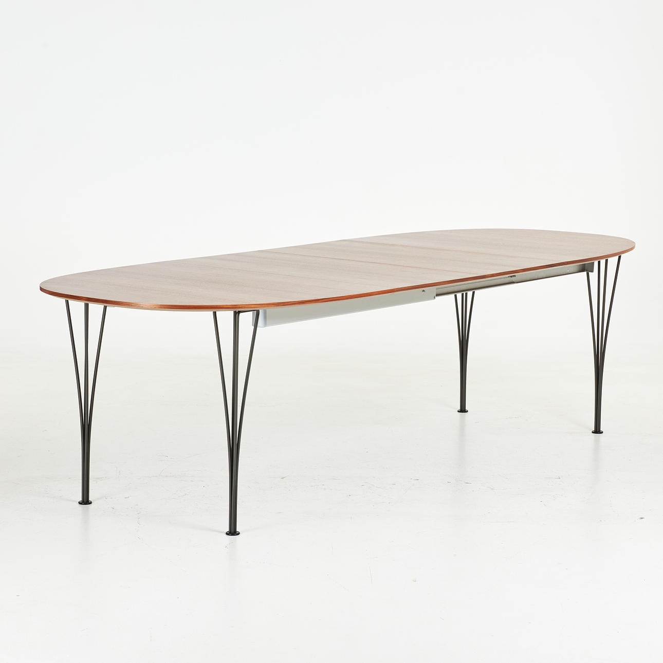 ARNE JACOBSEN, BRUNO MATHSSON, PIET HEIN. Superellipse, Fritz Hansen 2021, table top veneered in walnut with aluminum edge, black lacquered legs, with two insert plates.