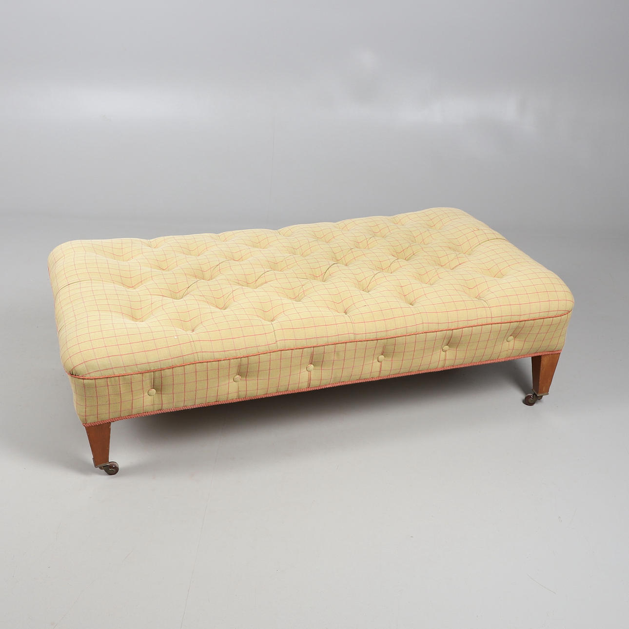 A RECTANGULAR BUTTON TOPPED LARGE STOOL.