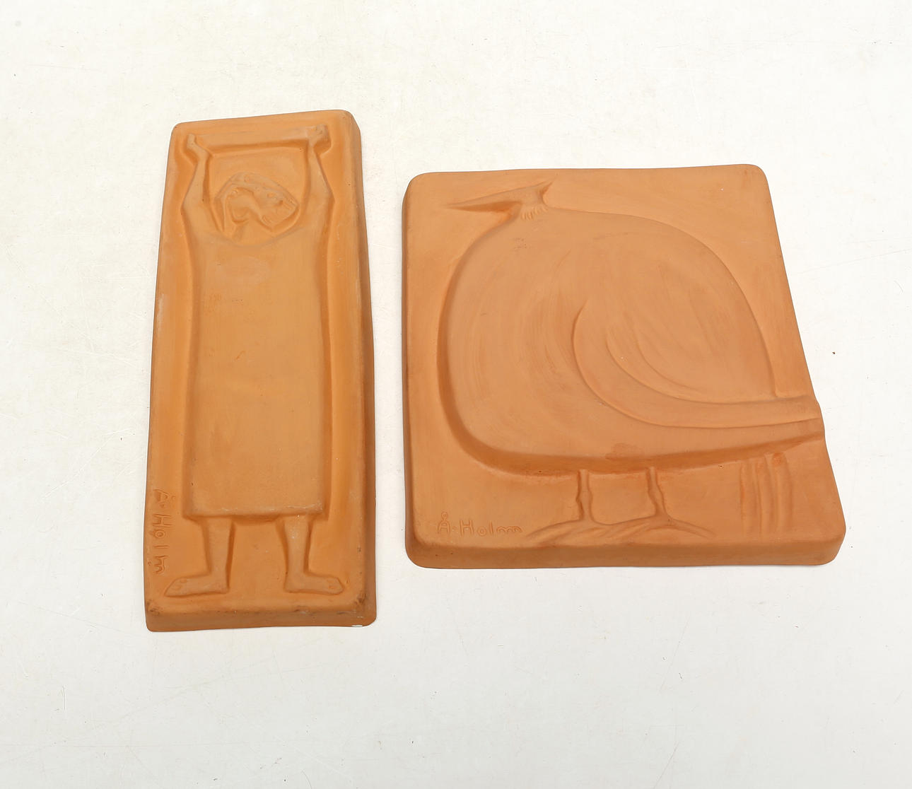 ÅKE HOLM. TWO TERRACOTTA WALL RELIEFS, signed.