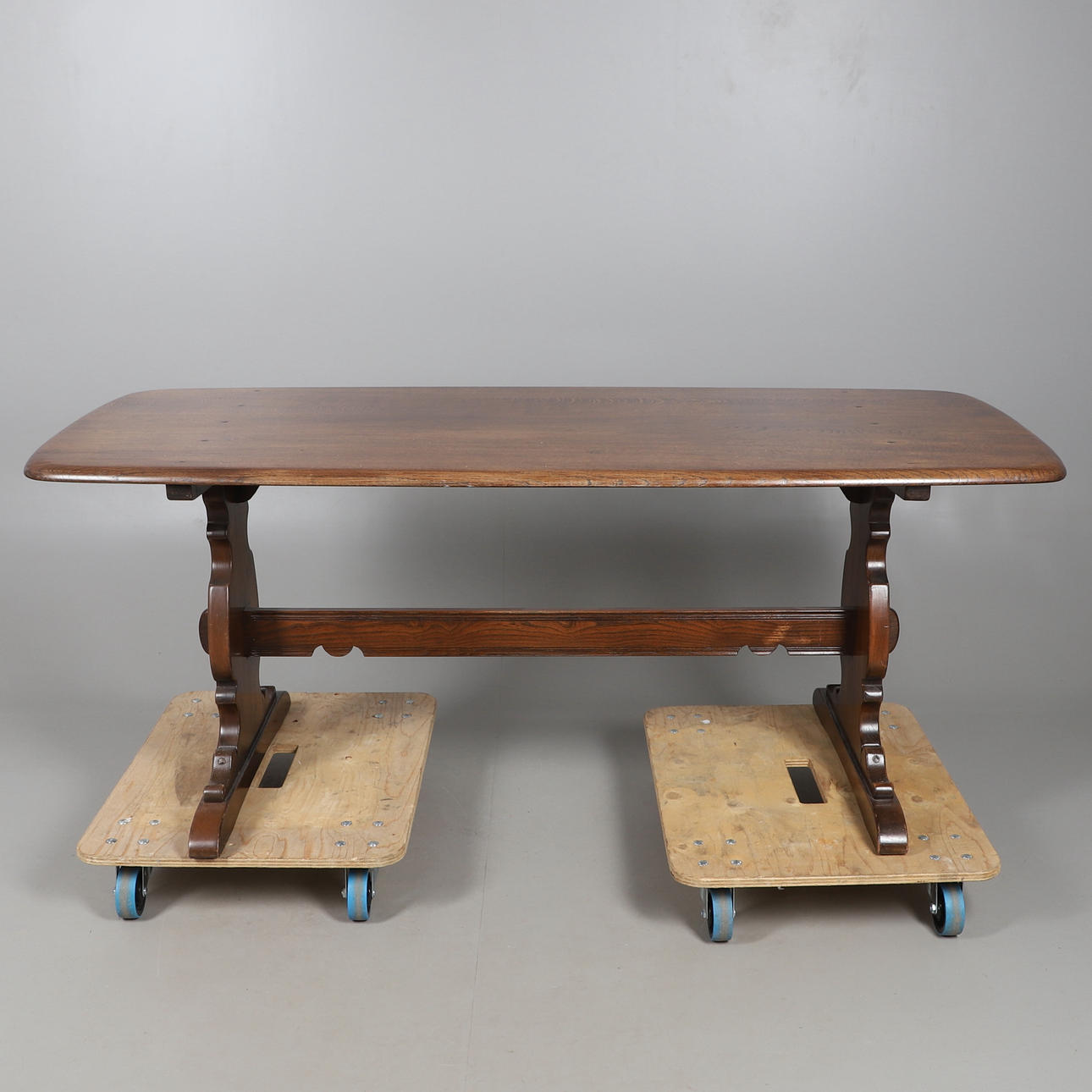 AN ERCOL ELM DINING TABLE.
