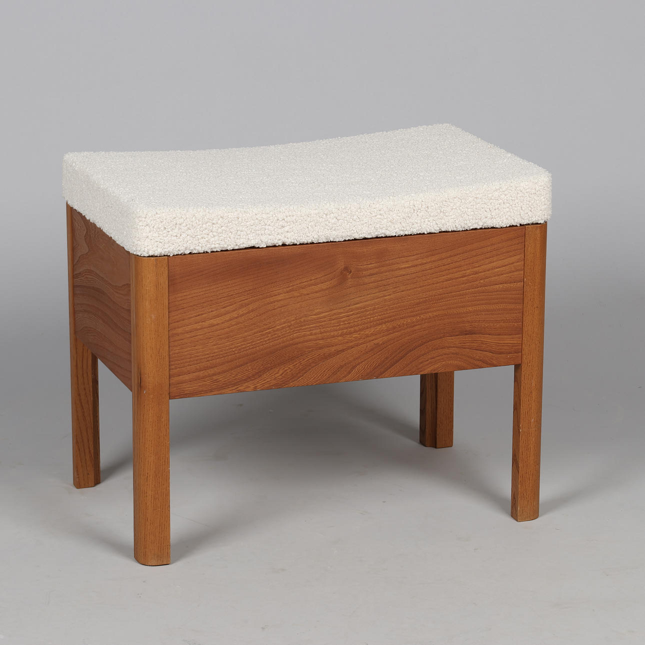 DANSK SNEDKERMESTER. Stool with storage of elm, top freshly upholstered with bright Bouclé, Denmark, mid 1900's.
