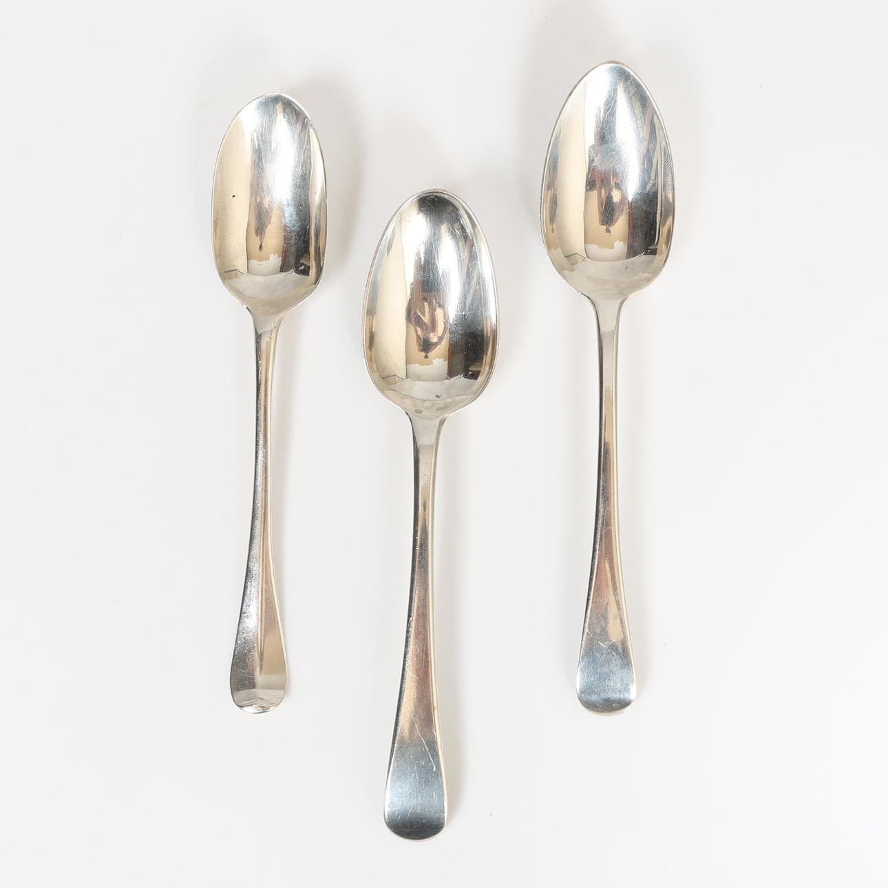 THREE GEORGIAN SILVER DESSERT SPOONS, VARIOUS DATES AND MAKERS (3).