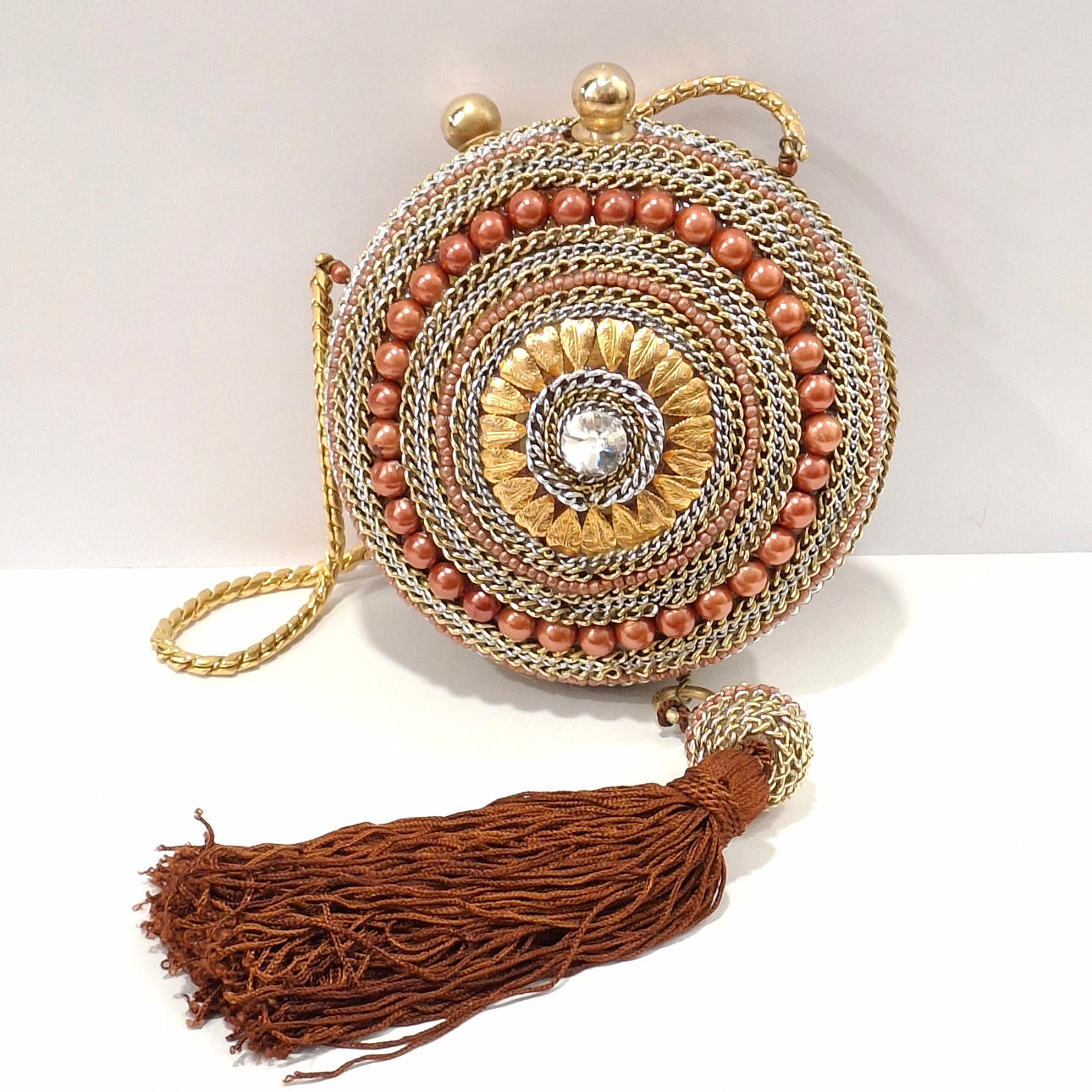 Rigid party bag with chain applications in shades of brown and gold. With pompom.