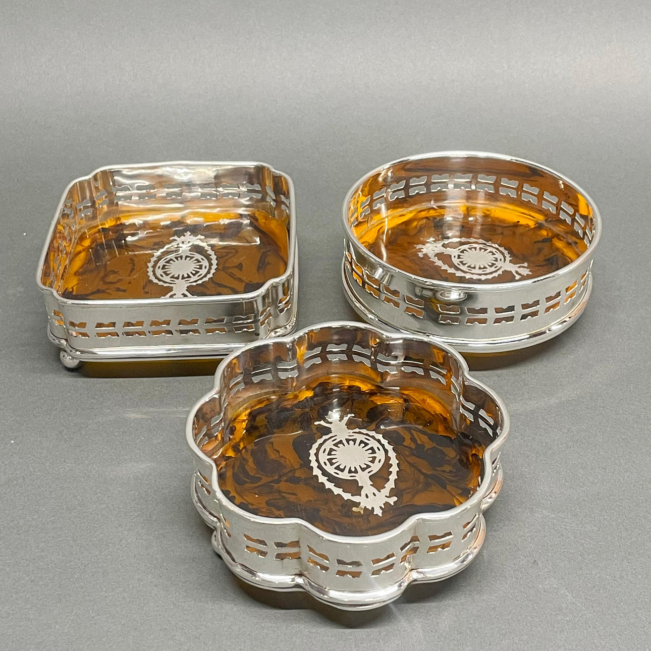 THREE SILVER PLATED WINE COASTERS.