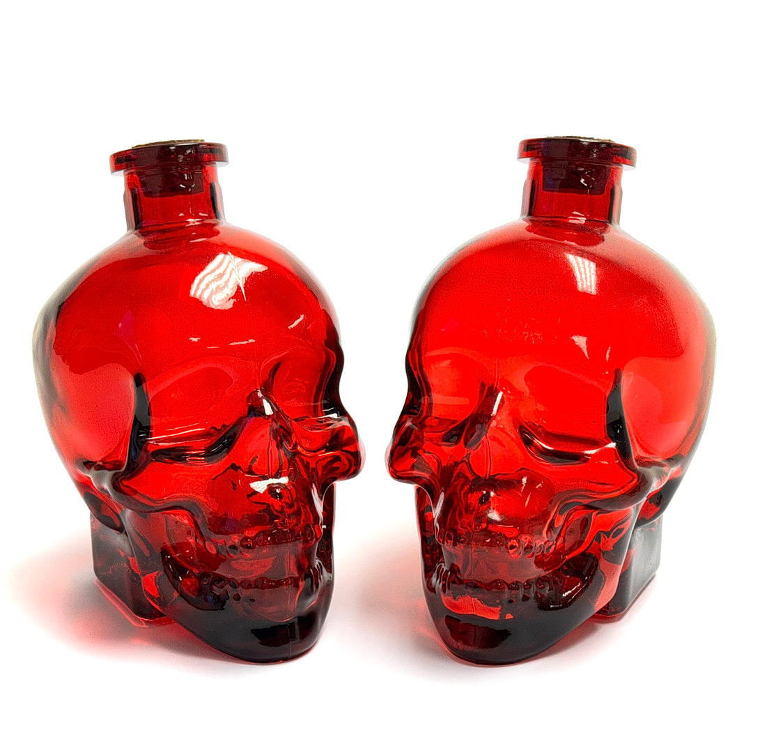 TWO GLASS SKULL BOTTLES.