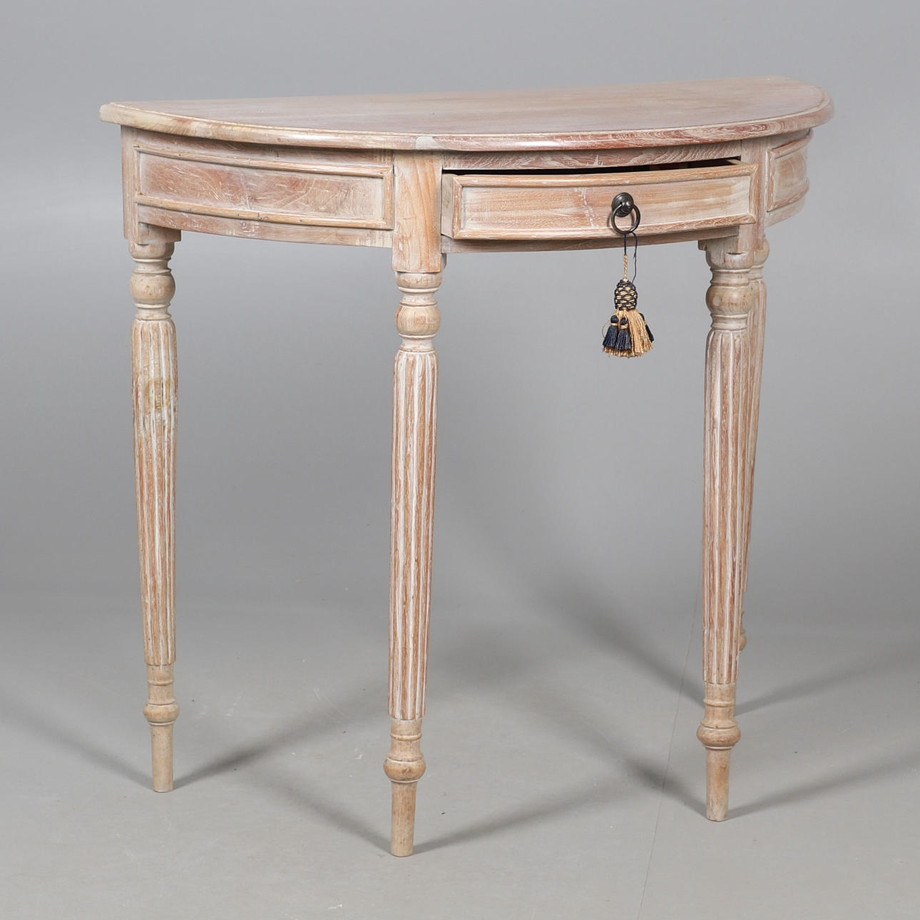 A LIMED WOOD HALF ROUND HALL TABLE.
