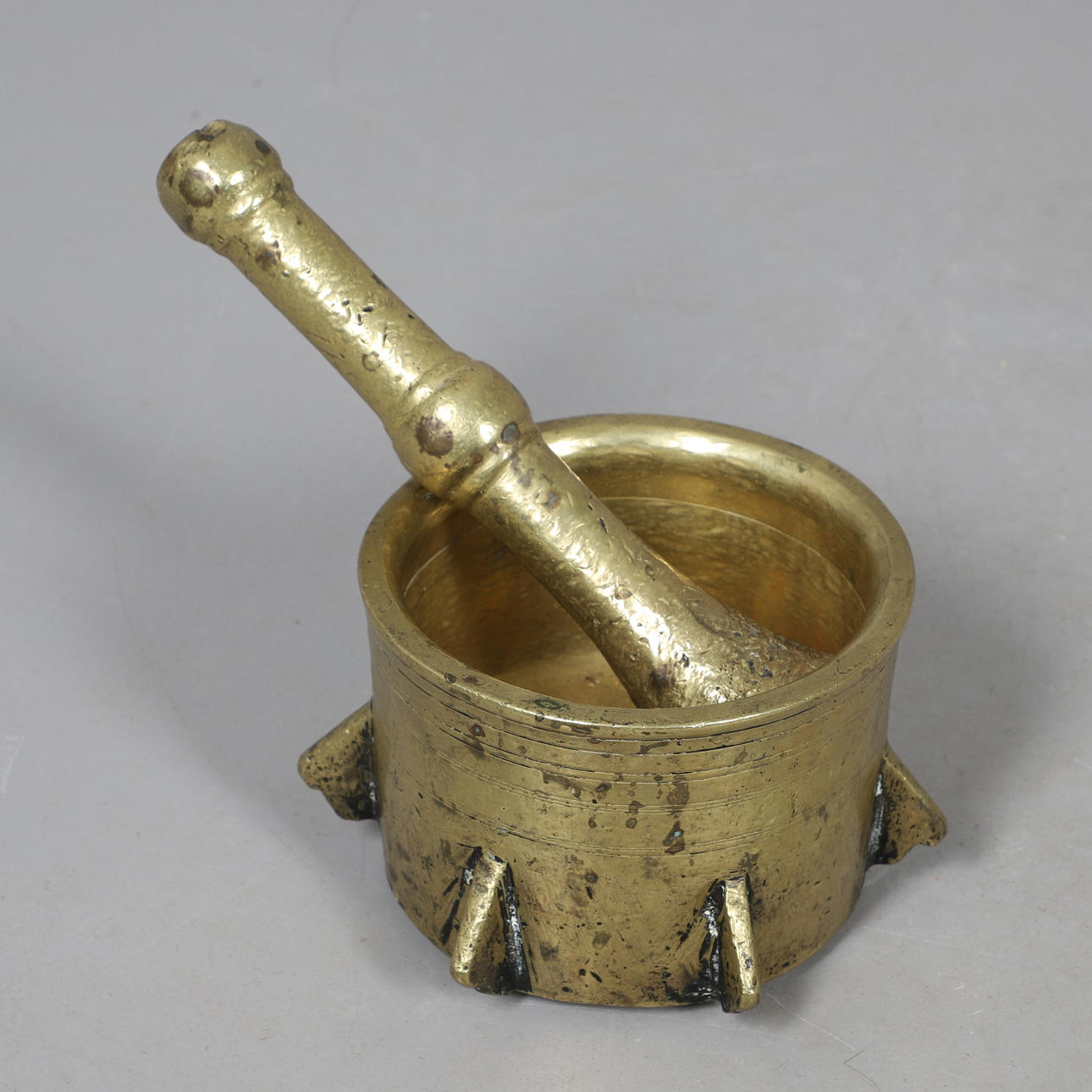 AN EGYPTIAN BRASS MORTAR AND PESTLE.