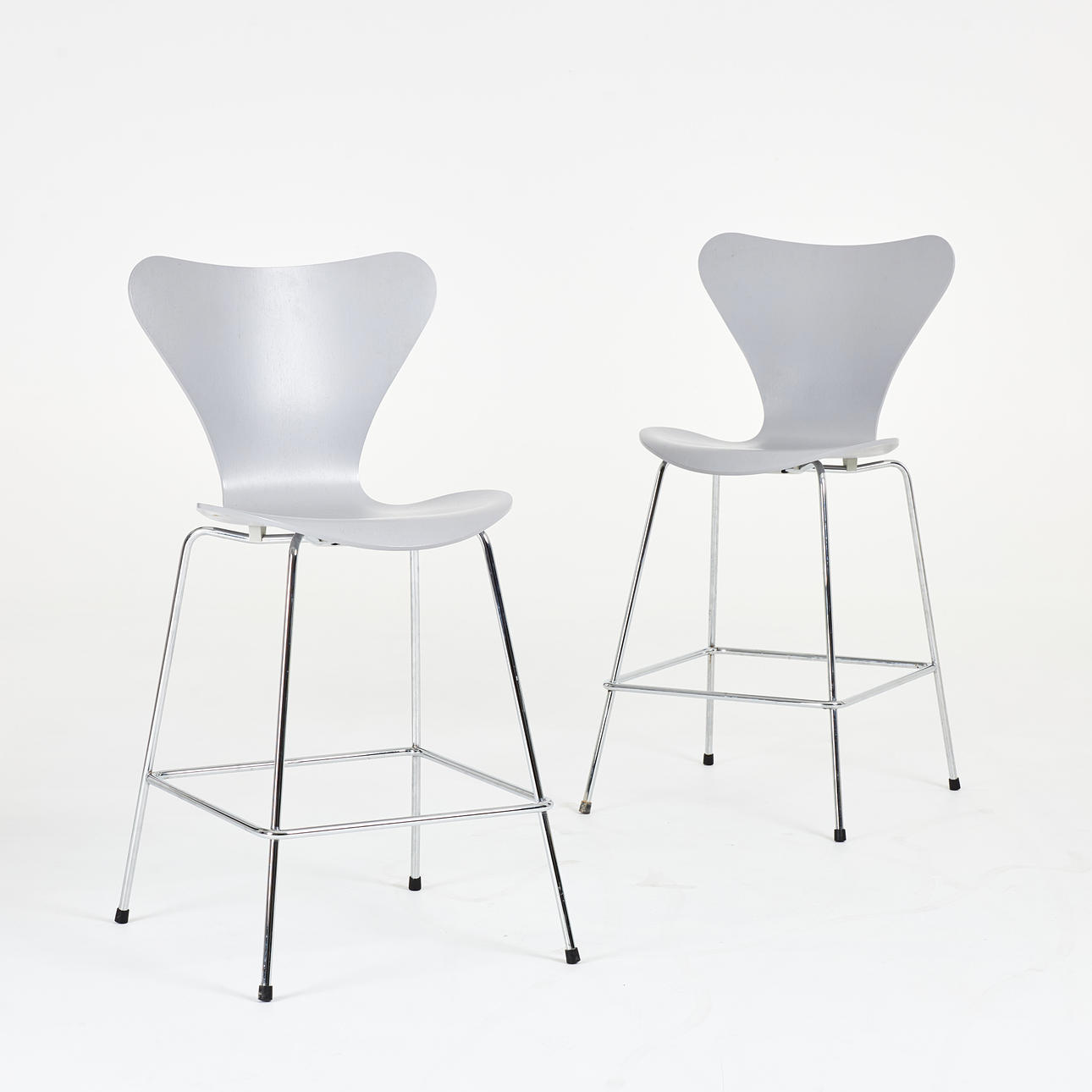 ARNE JACOBSEN. Bar stools, 1 pair, “Sjuan” for Fritz Hansen, model “3187 High”, label marked. Original designed in 1955, seat in grey-lacquered molded veneer, frame in chrome-plated steel.
