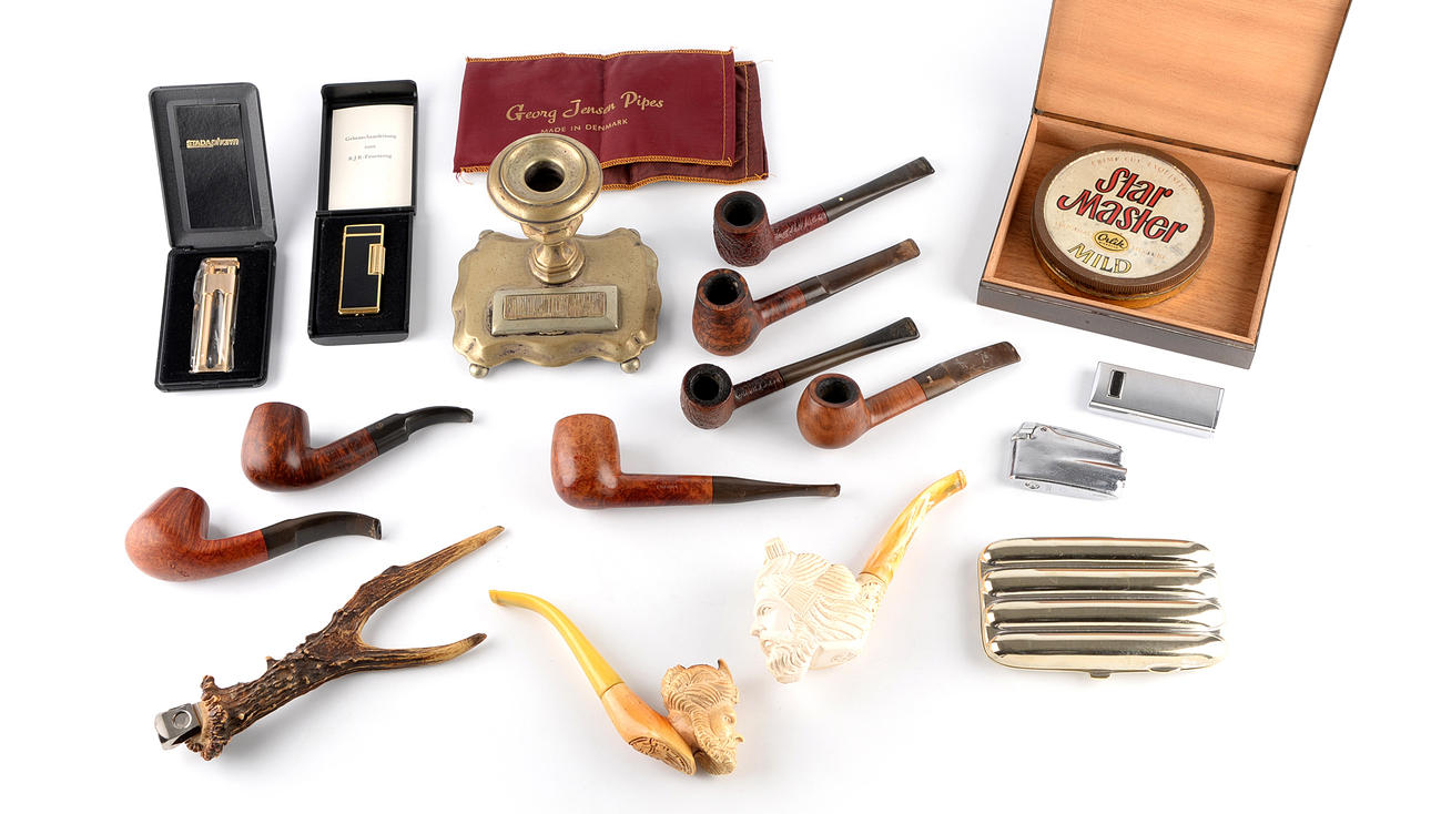En samling rökredskap. rör, cigarrskärare och låda.