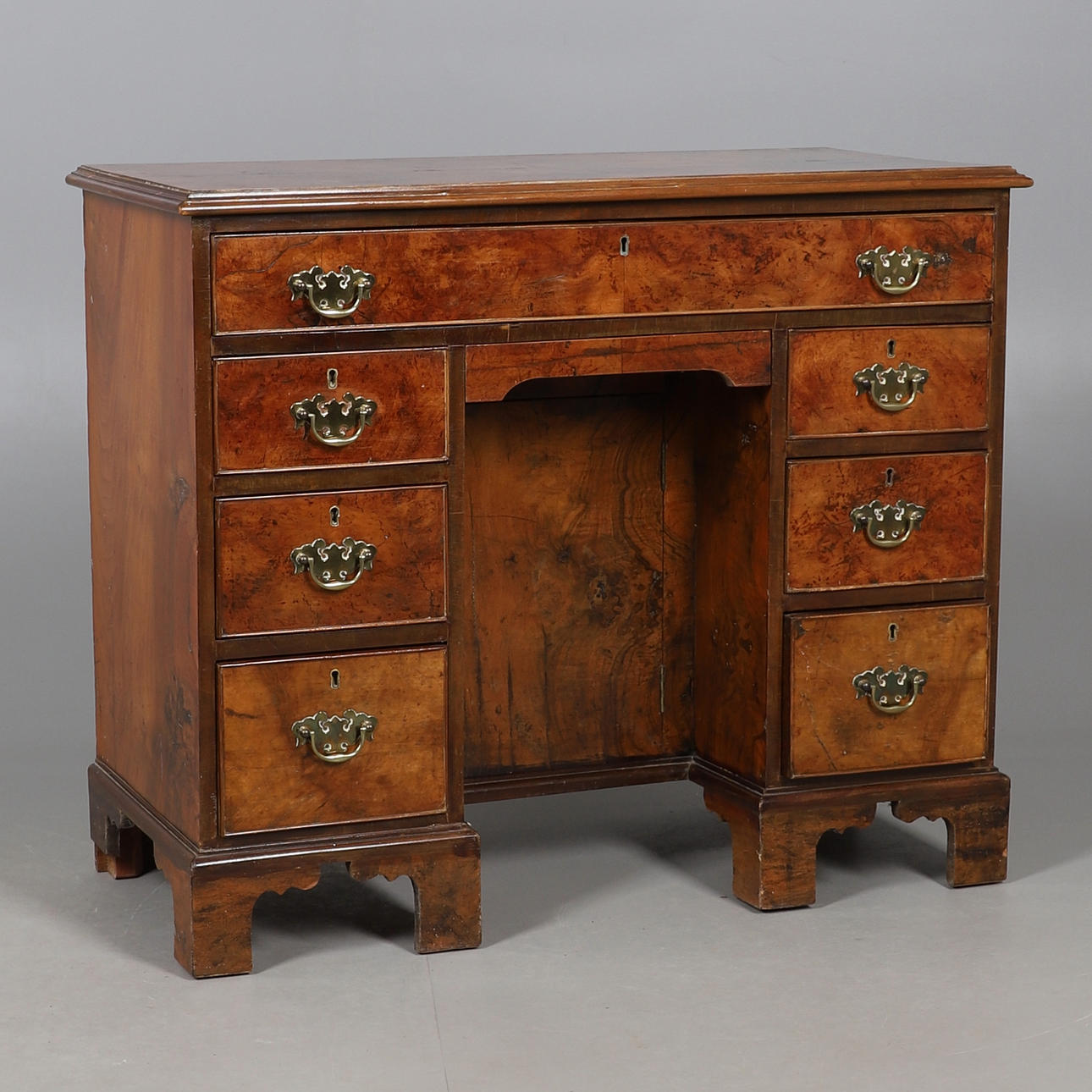 A WALNUT KNEEHOLE DESK.