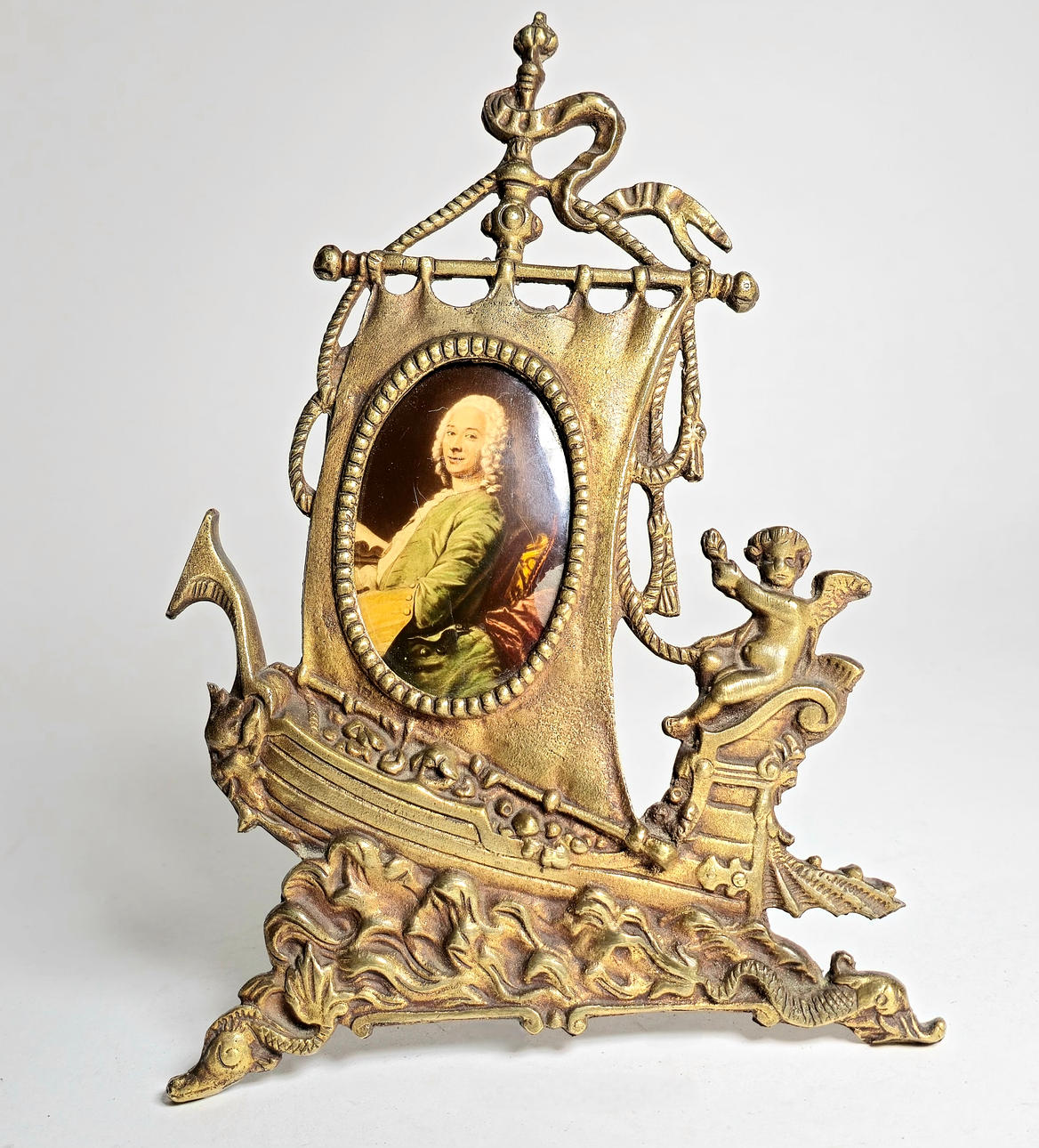 RAM MED BÅTMOTIV I GULDMETALL.