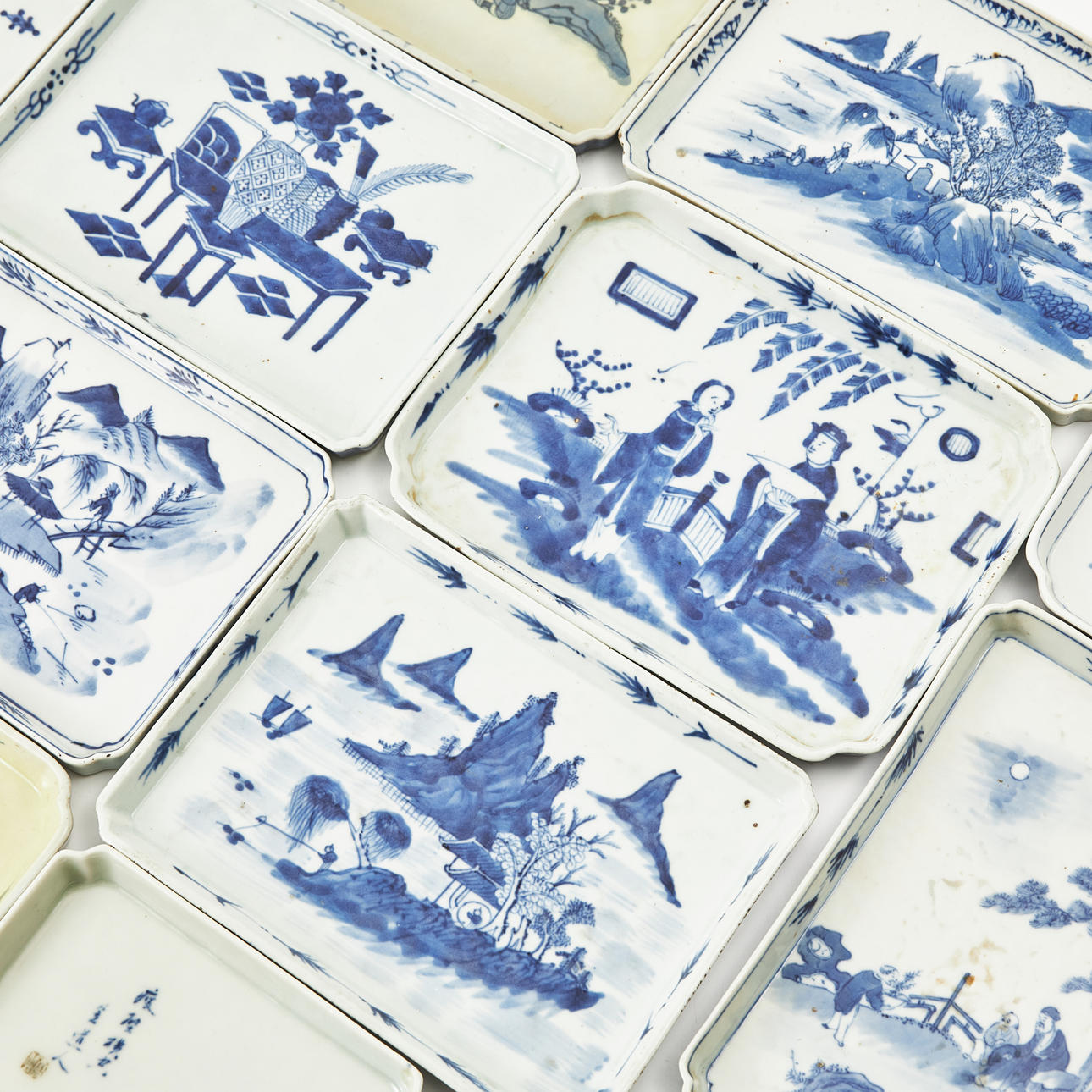 Un conjunto de once azulejos de porcelana china, del siglo XIX, con varias decoraciones azules bajo vidriado.