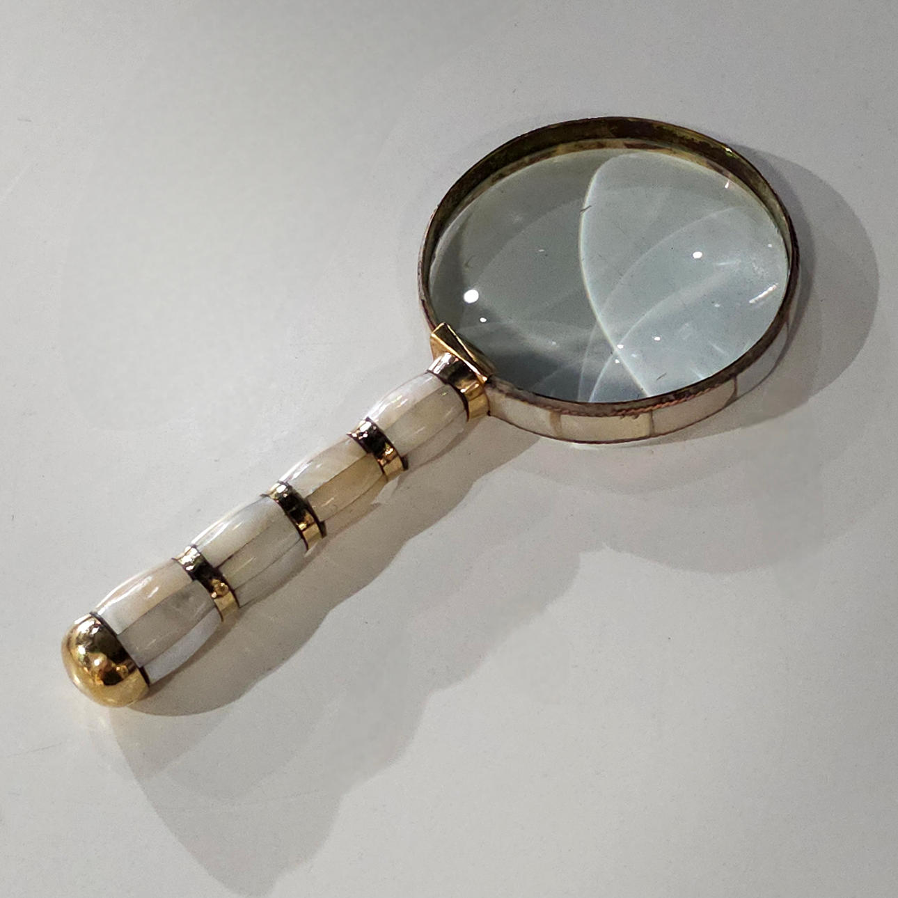 Kleine Lupe aus Goldmetall und Perlmutt.