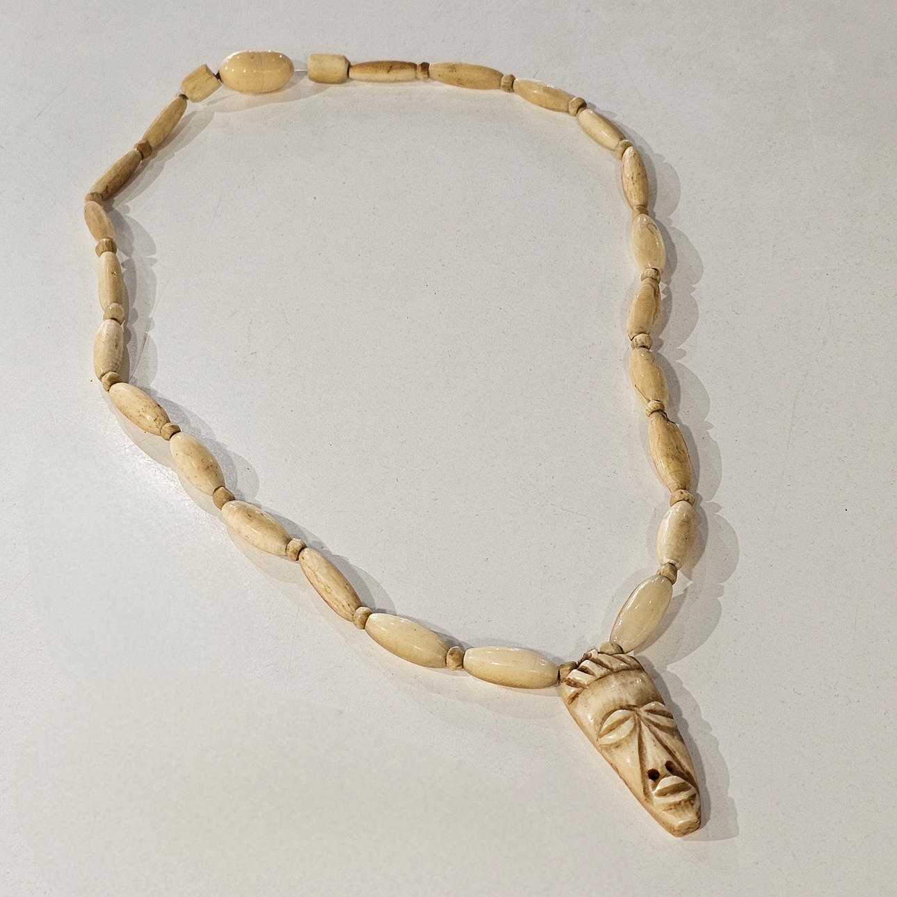 African mask necklace in bone.