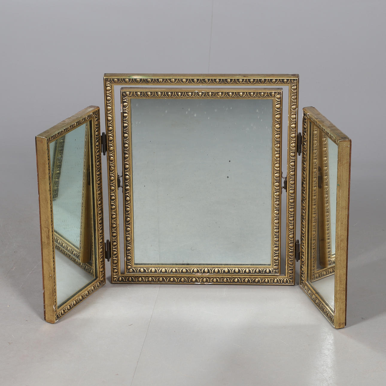 A MODERN GILT FRAMED FOLDING DRESSING TABLE MIRROR.