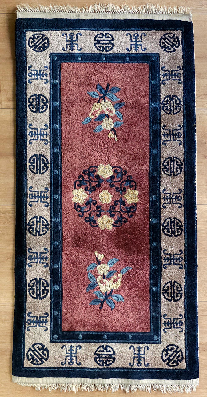 Silk carpet with rosette and flower motifs.
