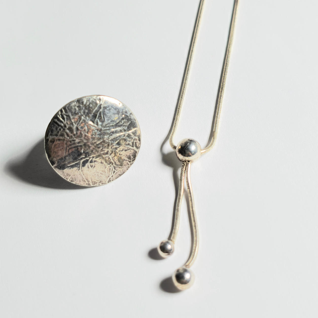 ADJUSTABLE SILVER NECKLACE AND RING.