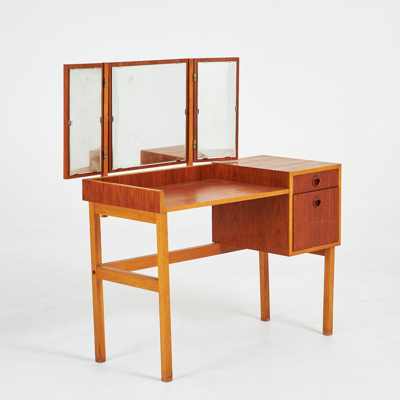 A 1950s/60s dressing table, oak and teak veneer. mirror in triptych, decorated boxes.