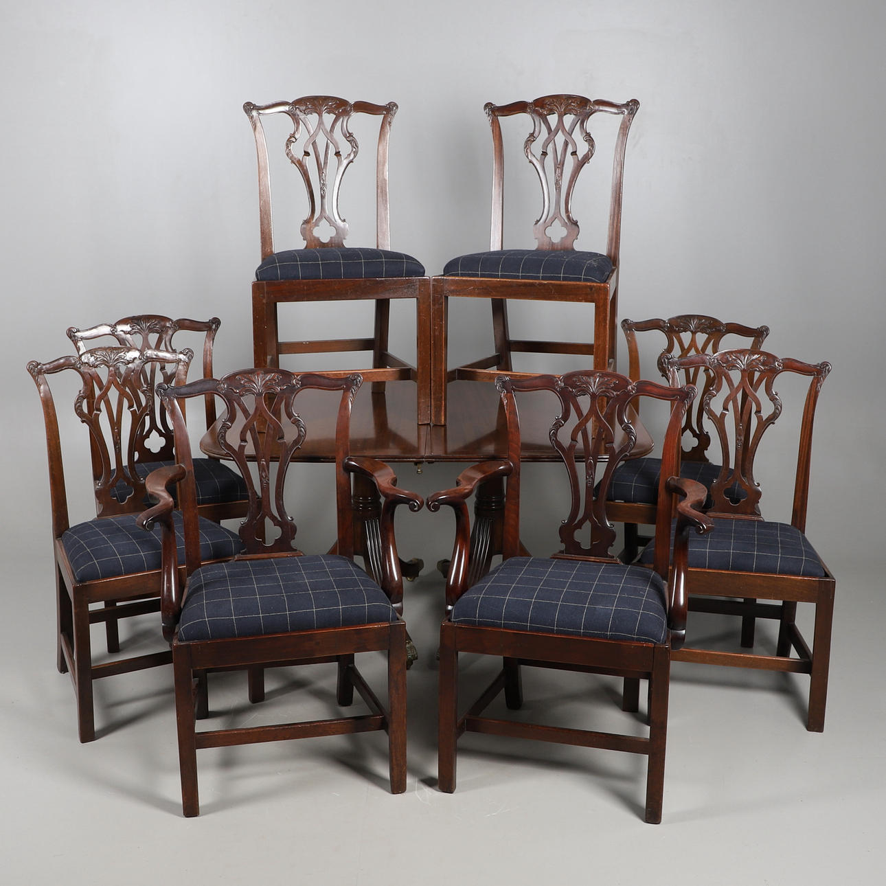 A MAHOGANY TWIN PILLAR DINING TABLE AND EIGHT CHIPPENDALE PATTERN DINING CHAIRS.