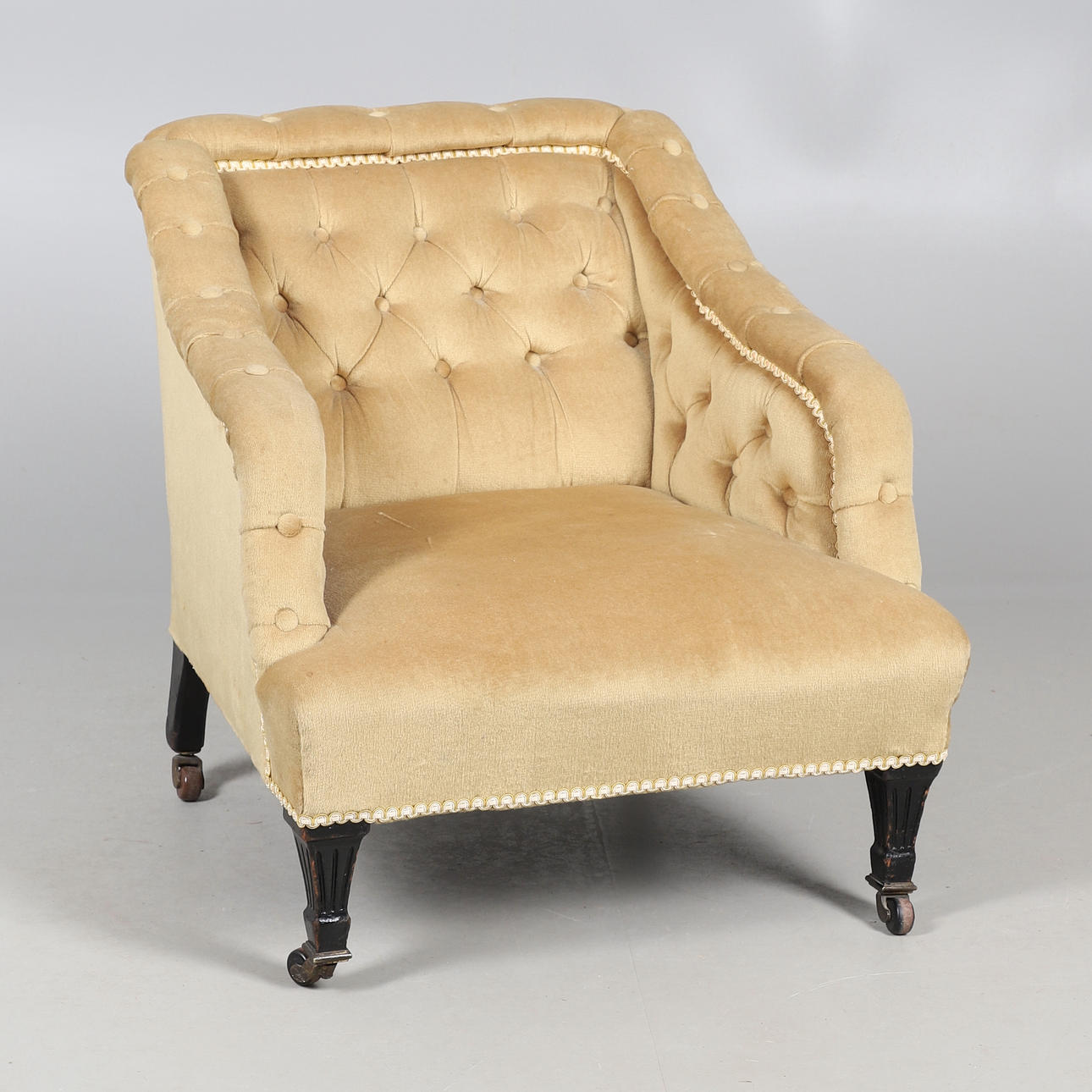 A LATE VICTORIAN AESTHETIC MOVEMENT BUTTON BACK EASY ARMCHAIR.