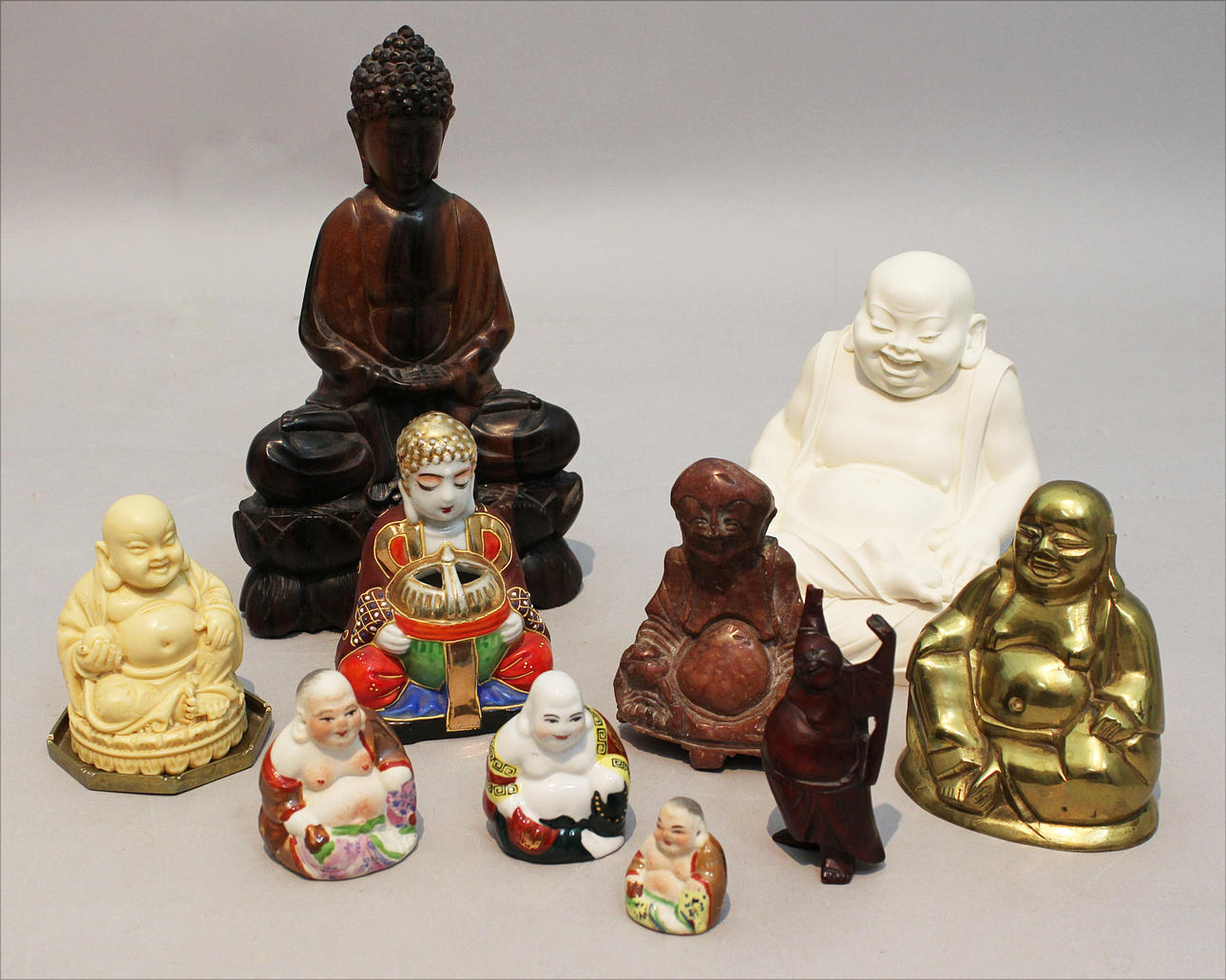 PARTI SKULPTURER, 10 stycken. Porslin, sten mässing, ben, trä. Buddha. Japan, 1950/60-tal.