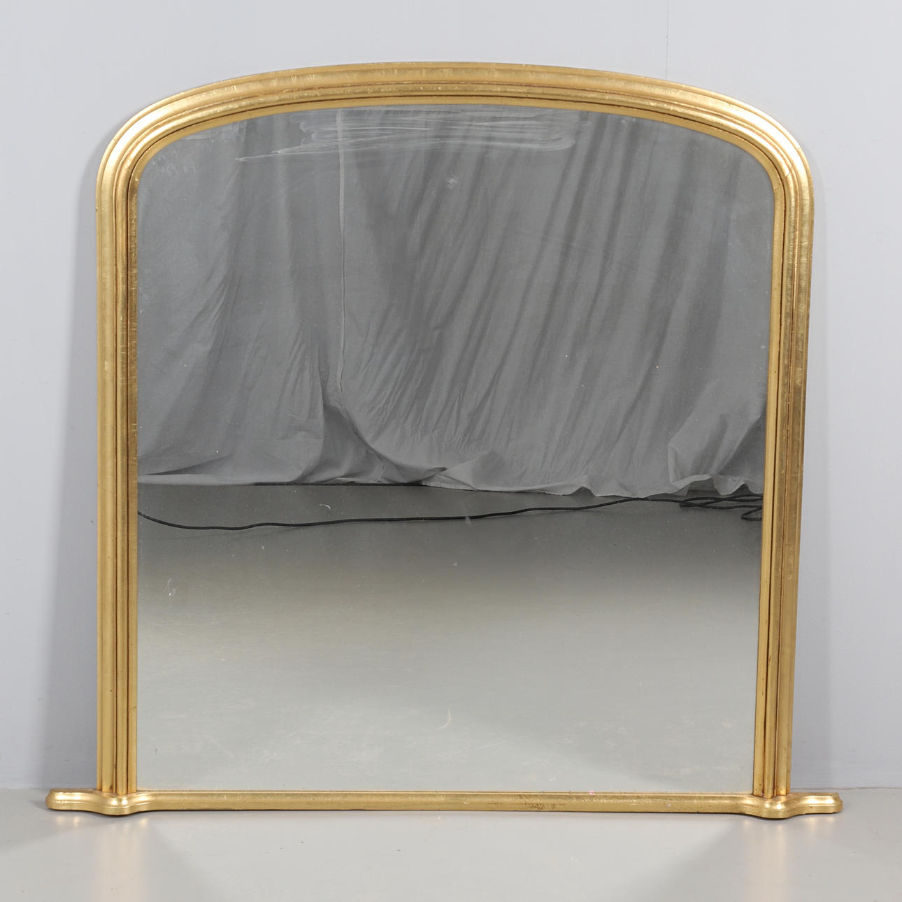 A GILT FRAMED OVERMANTLE MIRROR.