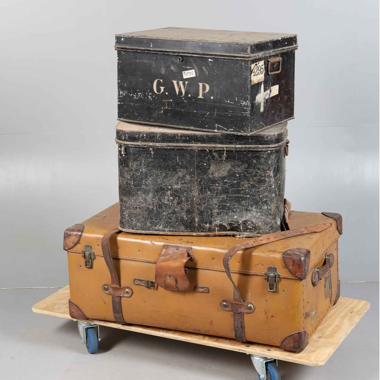 A LARGE LEATHER BOUND SUITCASE AND TWO METAL STORAGE BOXES (3).