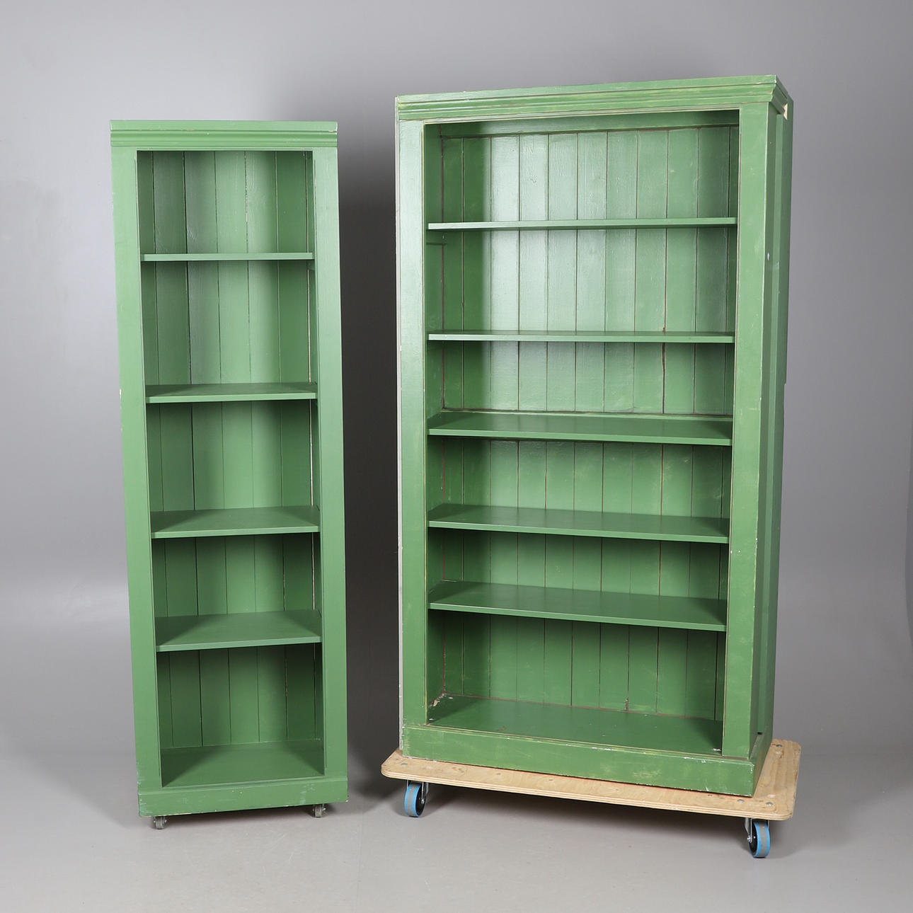 TVÅ MÅLADE ÖPPNA BOKHYLLOR.