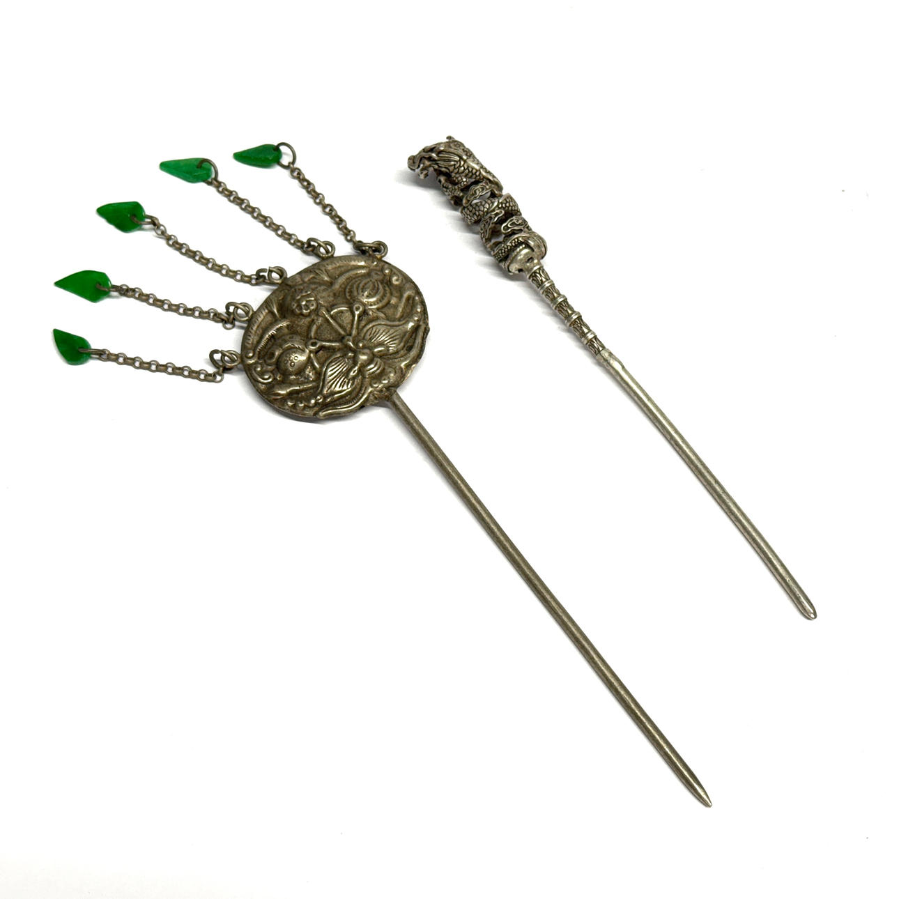 TVÅ KINESISKA HÅRPRYDNADER I VIT METALL.