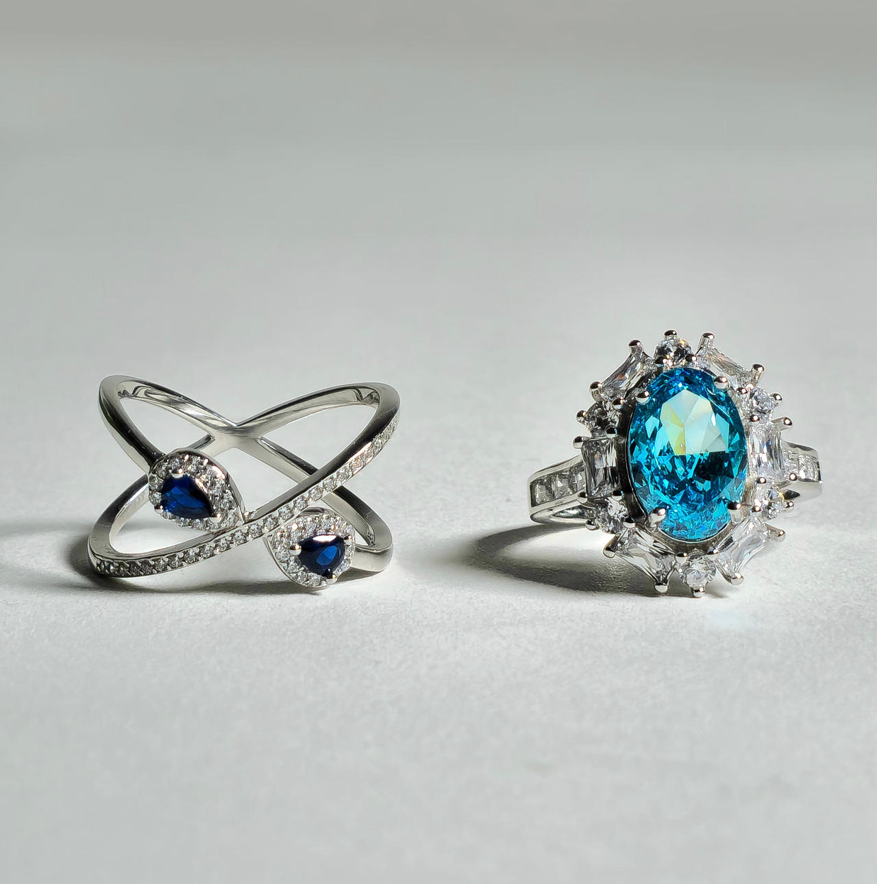TWO SILVER RINGS AND COLORED ZIRCONS.