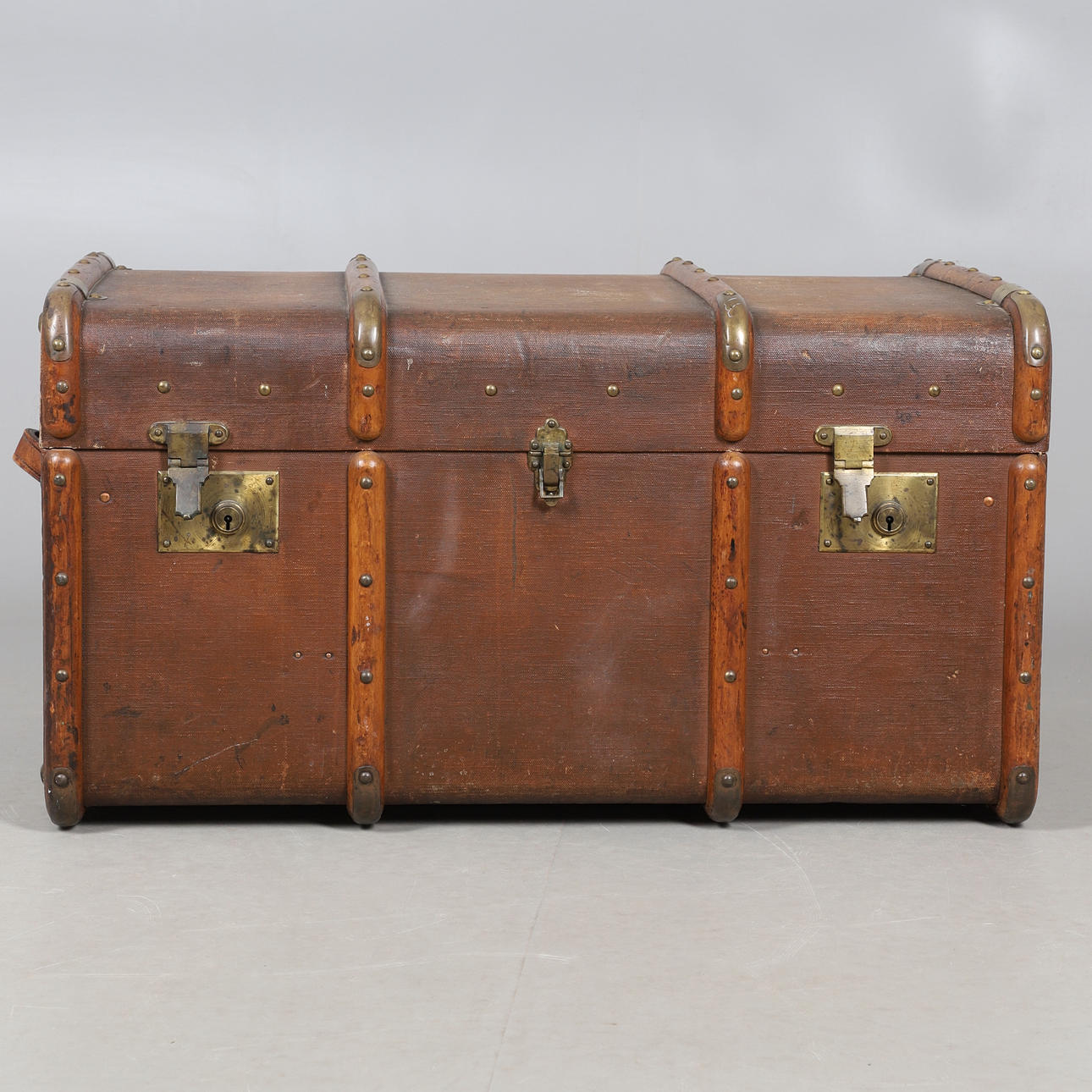 AN EARLY 20TH CENTURY CANVAS & BRASS BOUND TRUNK.