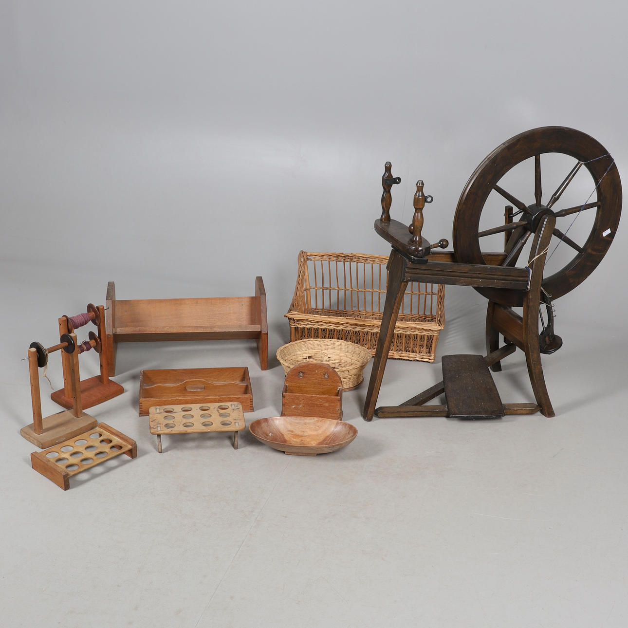 UNA RUECA, UNA CESTA DE MIMBRE Y OBJETOS DE MADERA.