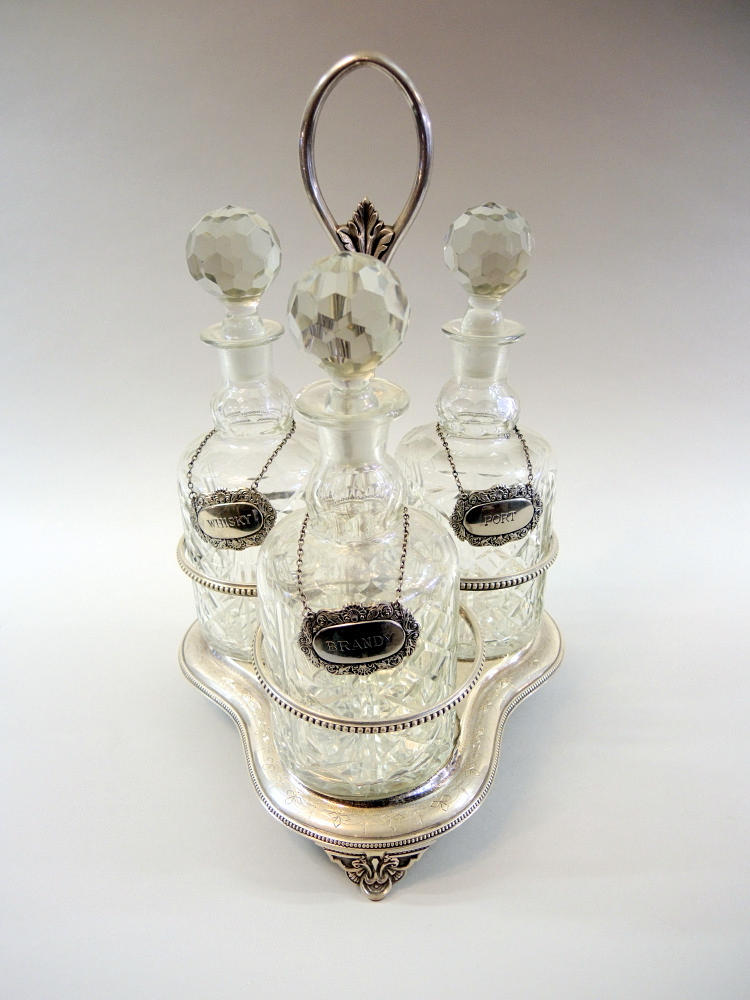 3 KARAFFER I SILVERPLÄTERAT STATIV.